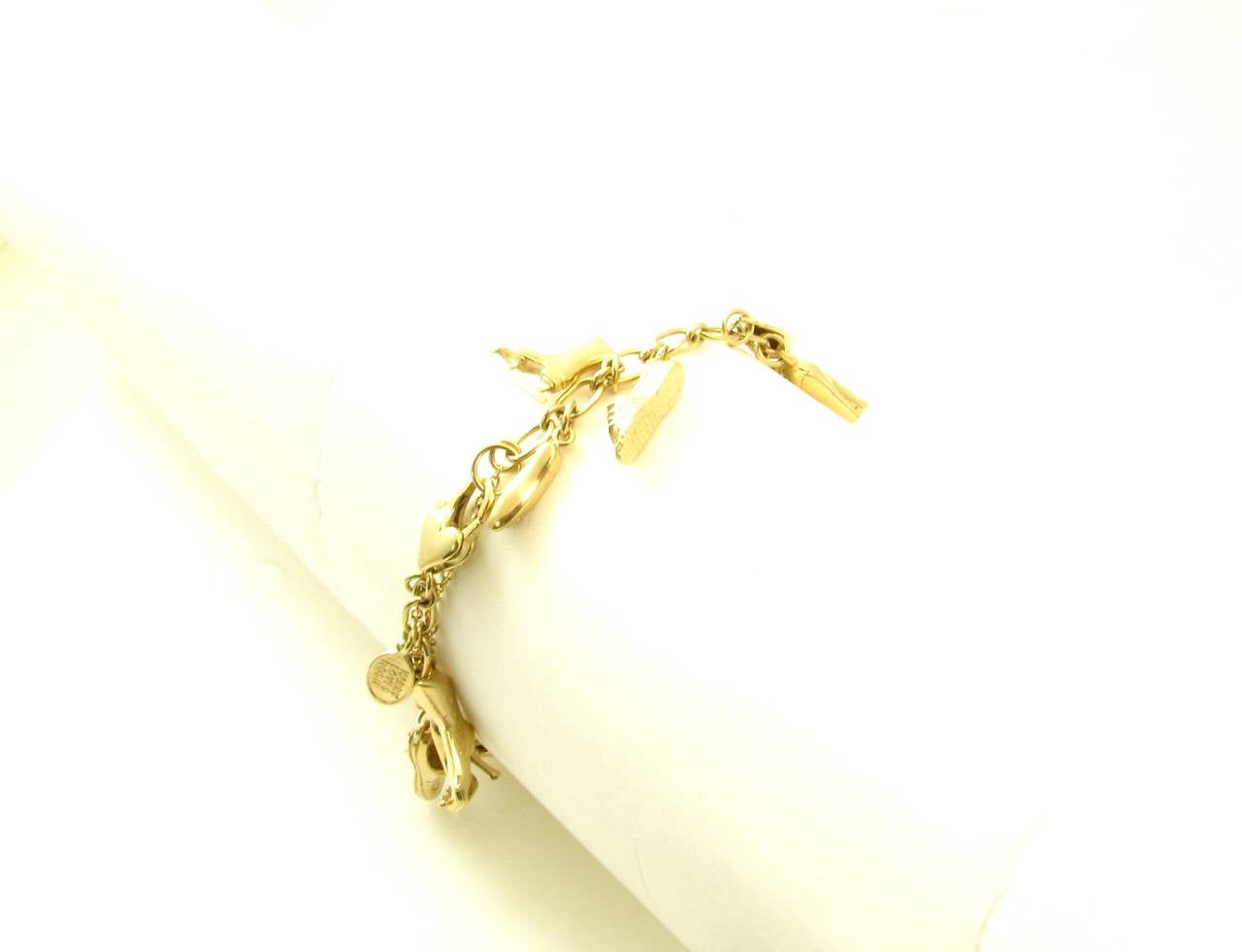 A 14 karat yellow gold charm bracelet “Harry loves Rosie”, Signed Tracey Zabar 585.  The oval link bracelet suspends 17 shoe charms.  The bracelet has a gross weight of approximately 47.0 grams and measures 7 inches long.