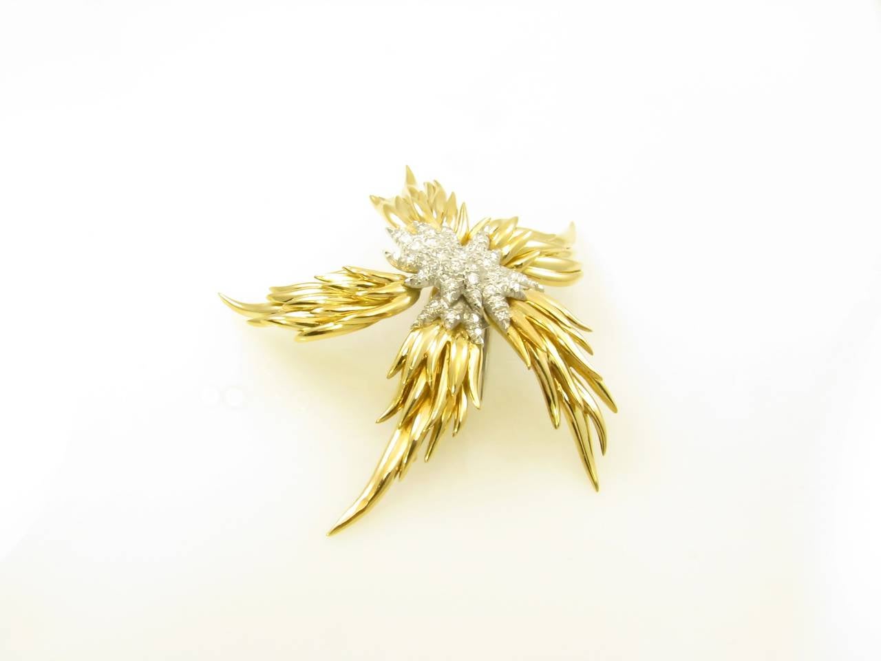 An 18 karat yellow gold, platinum and diamond set brooch.  Tiffany Schlumberger French.  The brooch is known as the flame.  Signed Tiffany Schlumberger, Made in France.  Gross weight approximately 37.6 grams and measures 3 inches long.  Circa 1980.