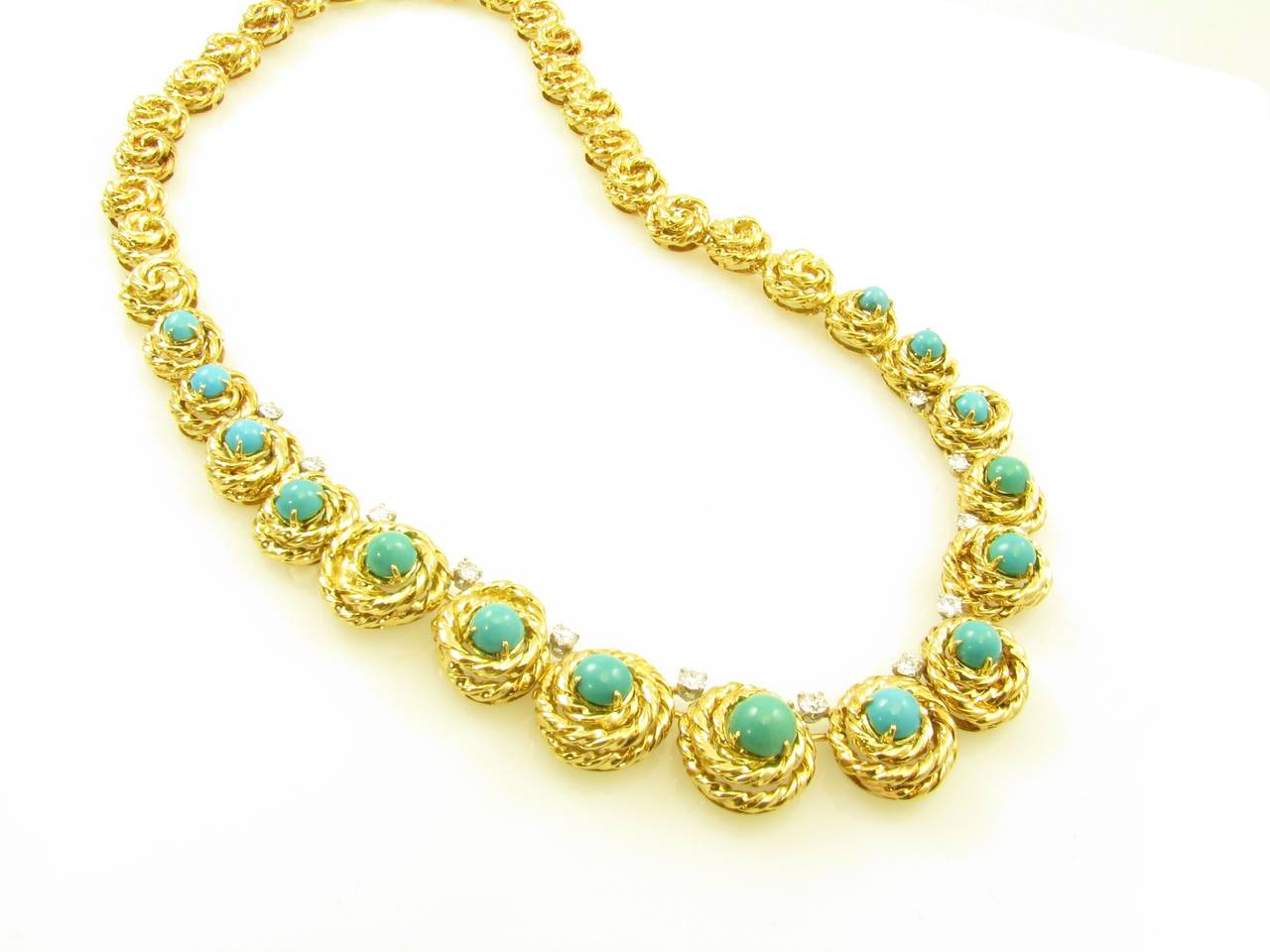 An 18 karat yellow gold, turquoise and diamond necklace.  Van Cleef and Arpels.  French.  Circa 1960.  The necklace is designed as continuous twisted gold knots set with a total of (15) fifteen cabochon turquoise and (12) twelve circular cut