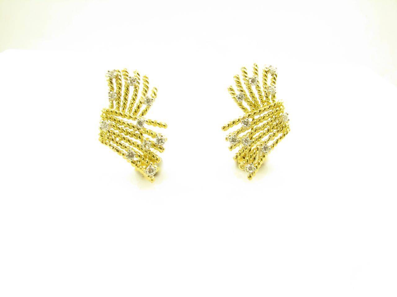 A pair of 18 karat yellow gold and platinum set diamond earrings.  Tiffany Schlumberger.  The design is known as the V-Rope, designed as wires of gold twisted together to form this rope design. Ear clips in 18k gold with round brilliant diamonds in