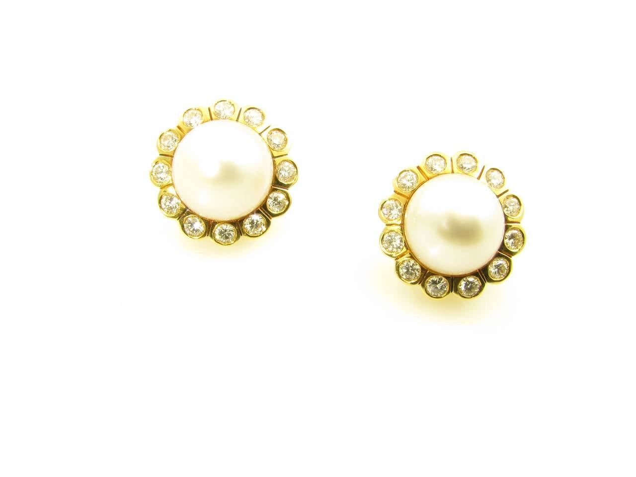 A pair of 18 karat yellow gold, South Sea pearl and diamond earrings, Signed Webb.  David Webb.  The earrings are each set with a South Sea button pearl measuring approximately 14.3 mm in diameter, within a cluster setting of 12 round brilliant cut