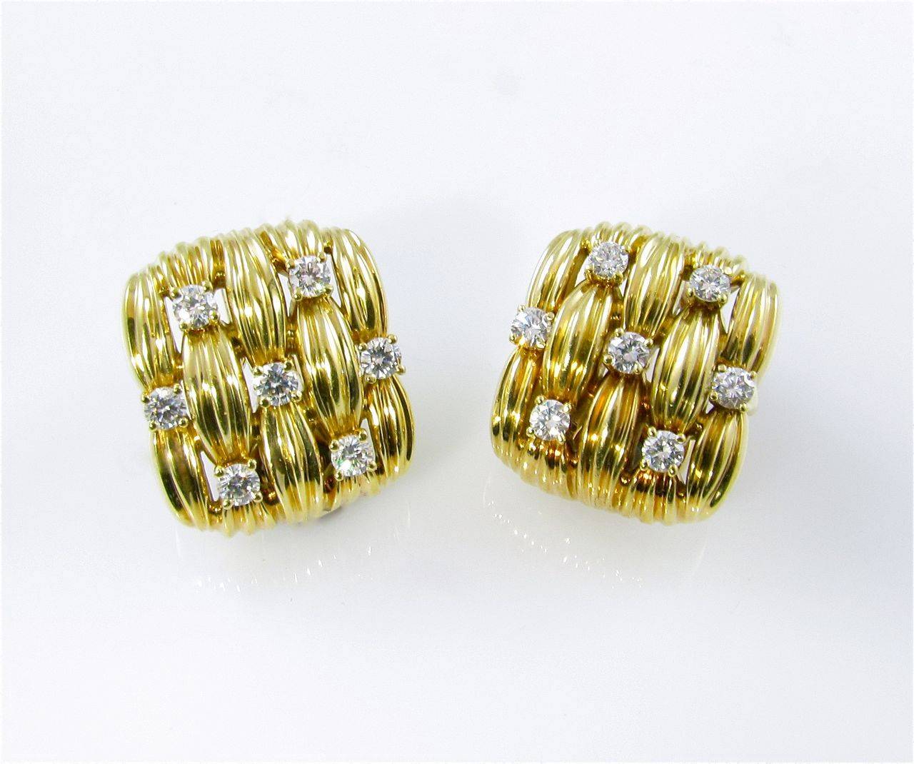 A pair of 18 karat yellow gold and diamond earrings, Tiffany & Co.  Signed ©1982 Tiffany & Co. 750.  The earrings are of square shape with fluted basketweave design, each earring set with 7 round brilliant cut diamonds.  The 14 diamonds weigh a