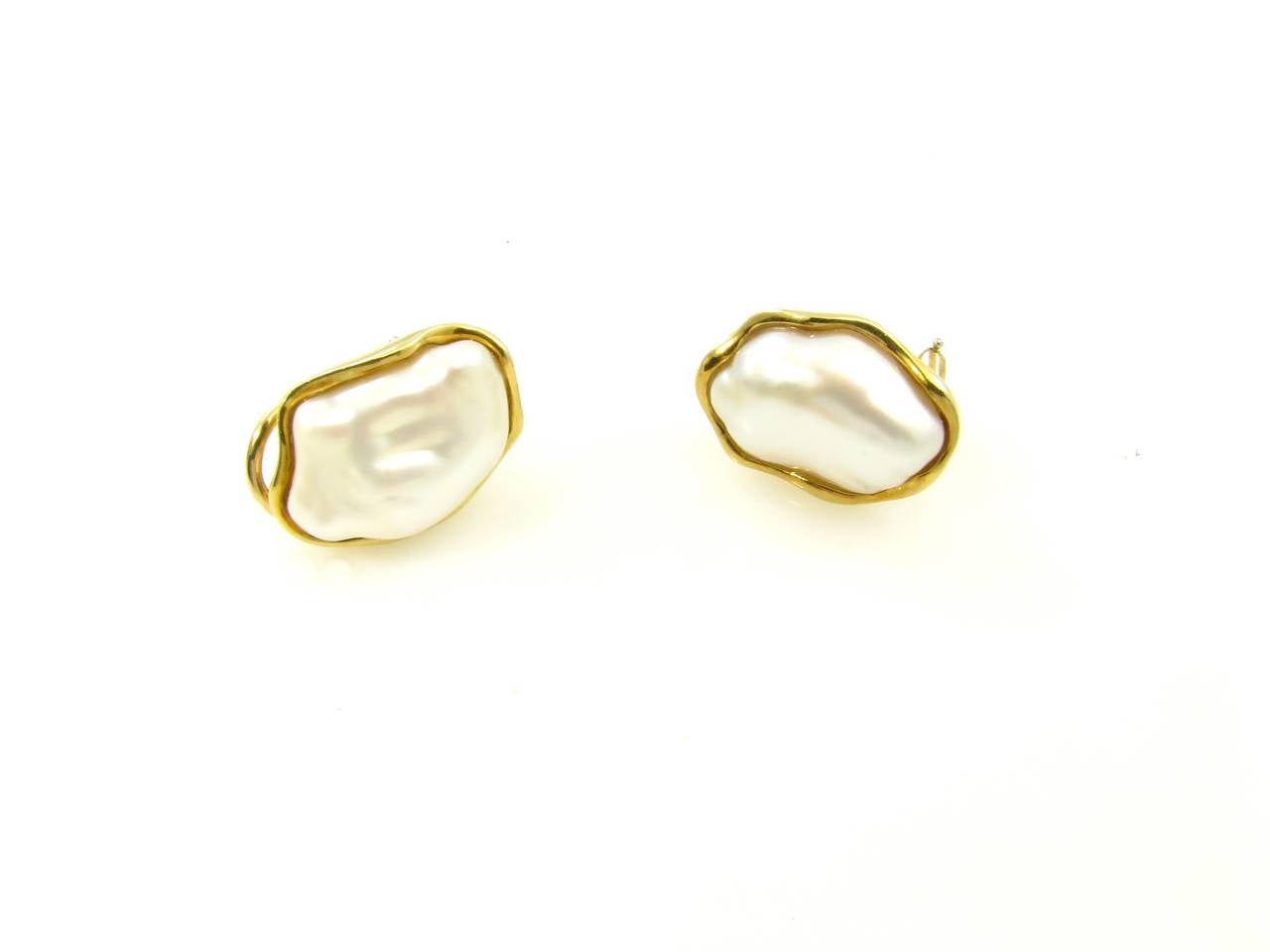 A pair of 18 karat yellow gold and Keshi pearl earrings, Tiffany & Co., Circa 1980s.  The earrings are designed as keshi pearls set within an 18 karat yellow gold conforming frame.  The earrings have a gross weight of approximately 14.3 grams and
