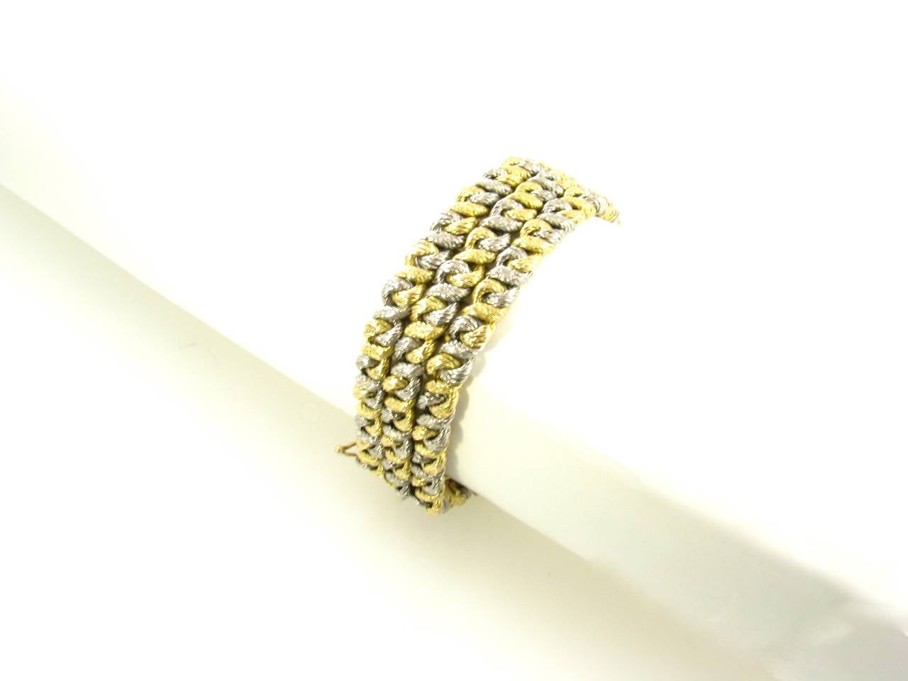 An 18 karat yellow and white gold bracelet, Bulgari, Circa 1960s.  Signed with maker’s mark for Georges L’Enfant and 18 karat gold French export mark, Signed Bulgari 750.  The bracelet is designed as 3 rows of alternating white and yellow gold