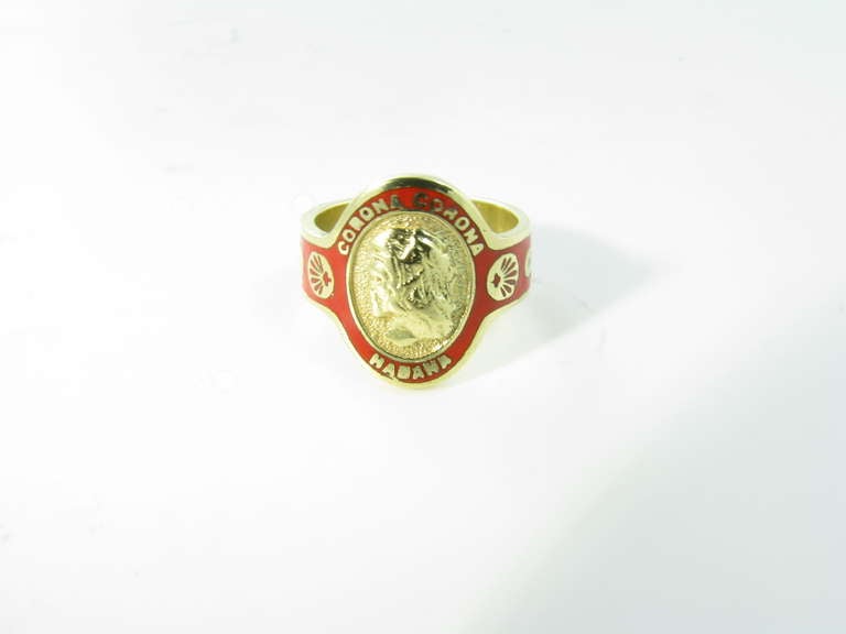 A Cartier 18 karat yellow gold and red enamel cigar band ring.  Circa 1970’s.  The ring is signed Cartier 18k.  The 18 karat yellow gold band is enameled in bright red enamel and reads “Corona Corona Habana”.  The ring is a size 5 3/4.  The ring has