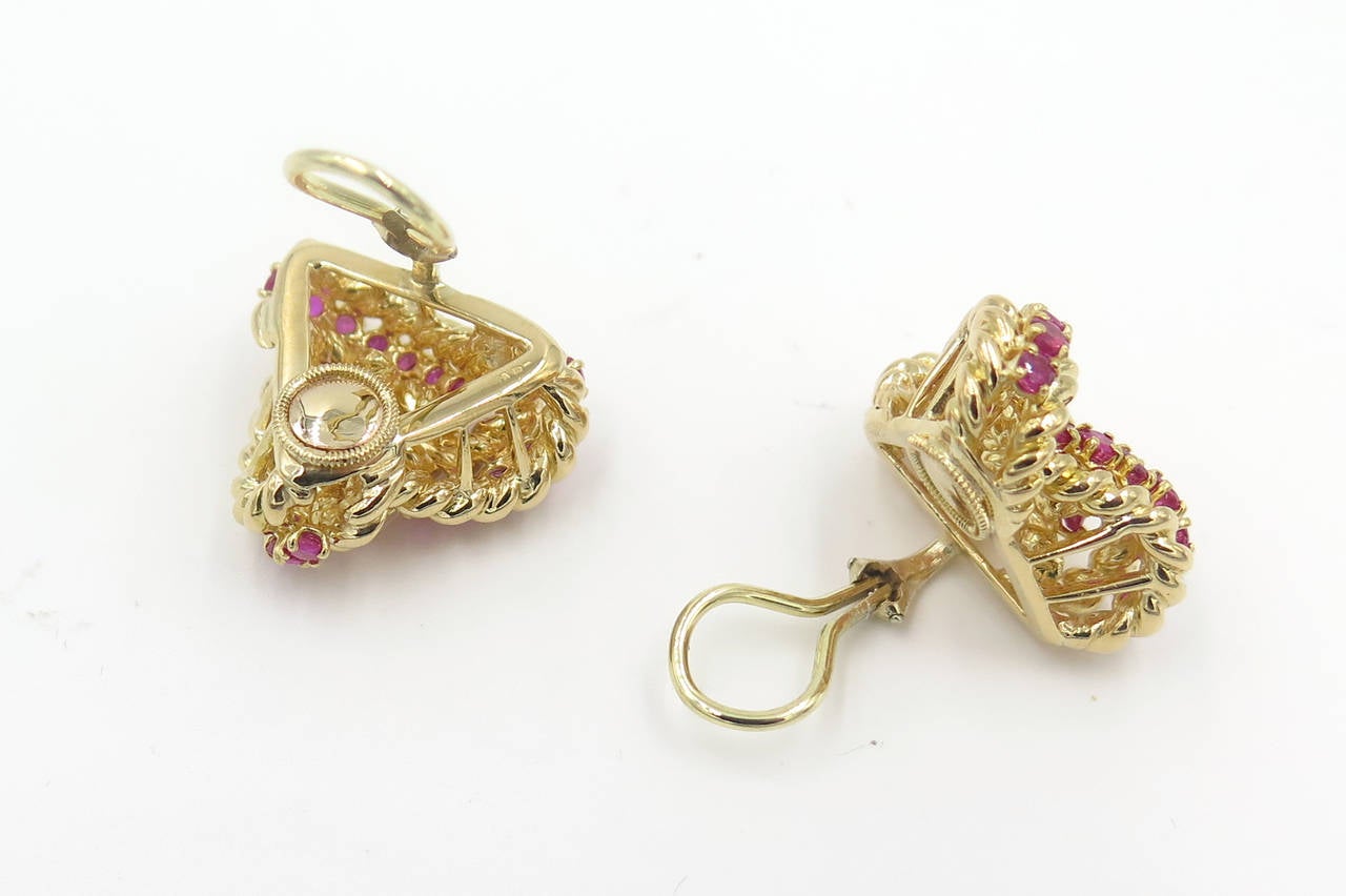 A pair of 18 karat yellow gold and ruby trefoil shaped earrings, Circa 1980s.  The earrings are of gold ropework style, set with a total of 42 faceted round rubies weighing a total of approximately 2.94 carats.  The earrings have a gross weight of