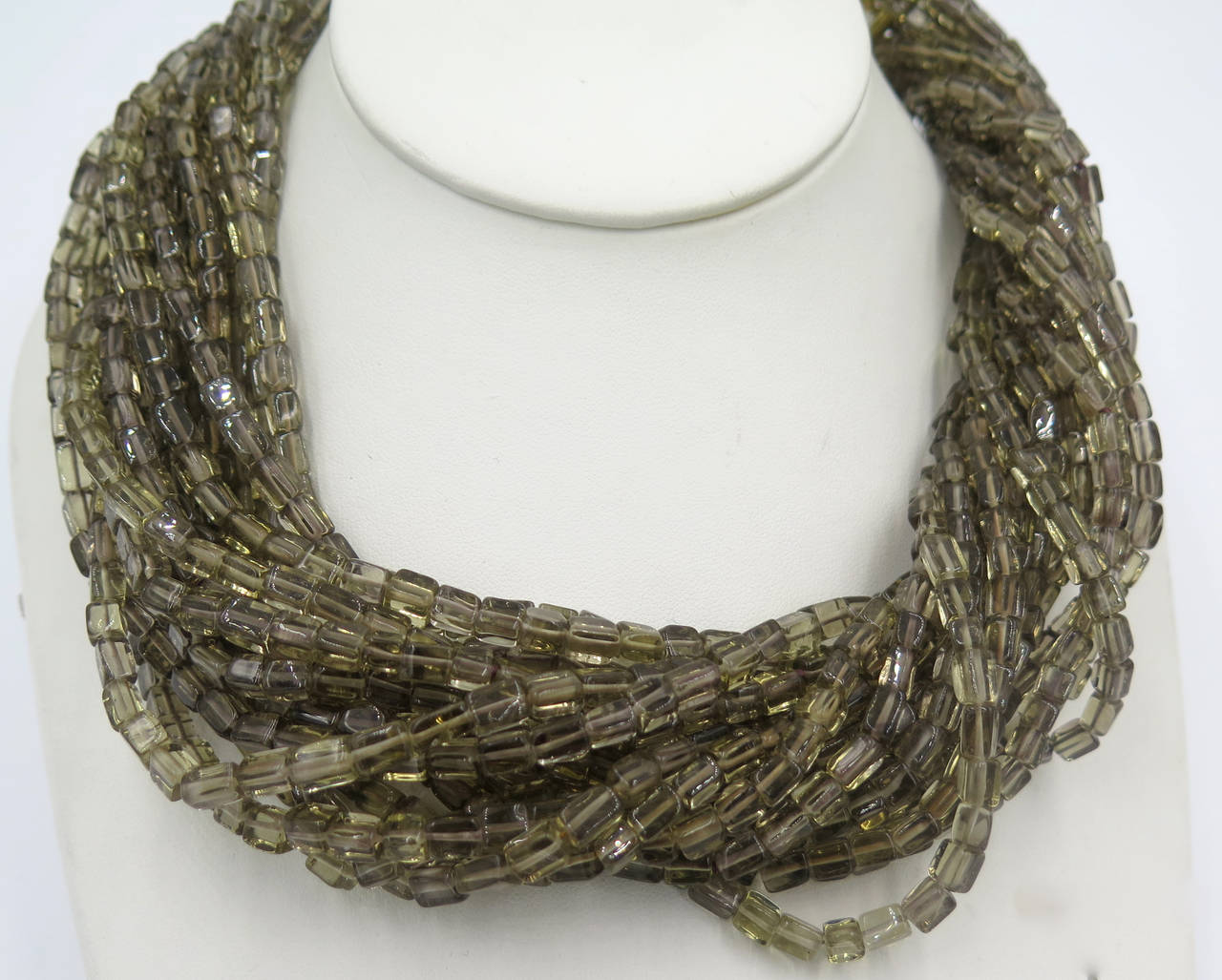A multistrand andalusite and colored diamond necklace, Marilyn Cooperman.  Consisting of seventeen strands of barrel shape andalusite beads strung with a sterling silver and 18 karat yellow gold double leaf motif clasp containing numerous pear shape