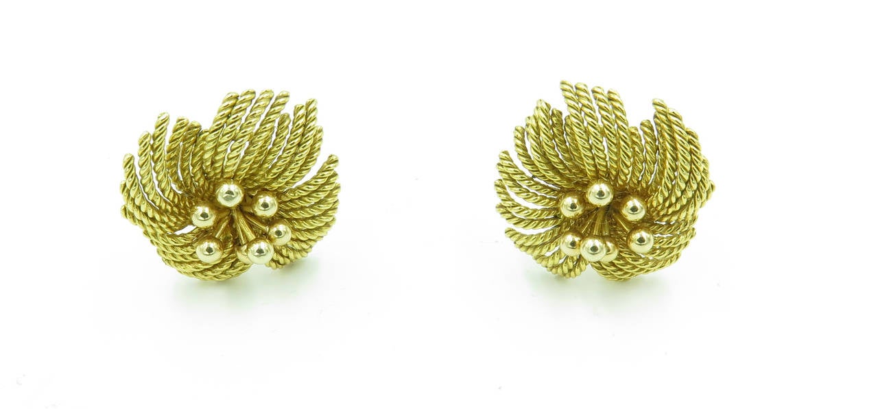 A pair of 18 karat yellow gold earrings, Van Cleef & Arpels, Circa 1960s.  Signed Van Cleef & Arpels, N.Y. 3V199.24.  The earrings are of gold rope set in a flower form with bold beads in the center of each.  The earrings have a gross weight of