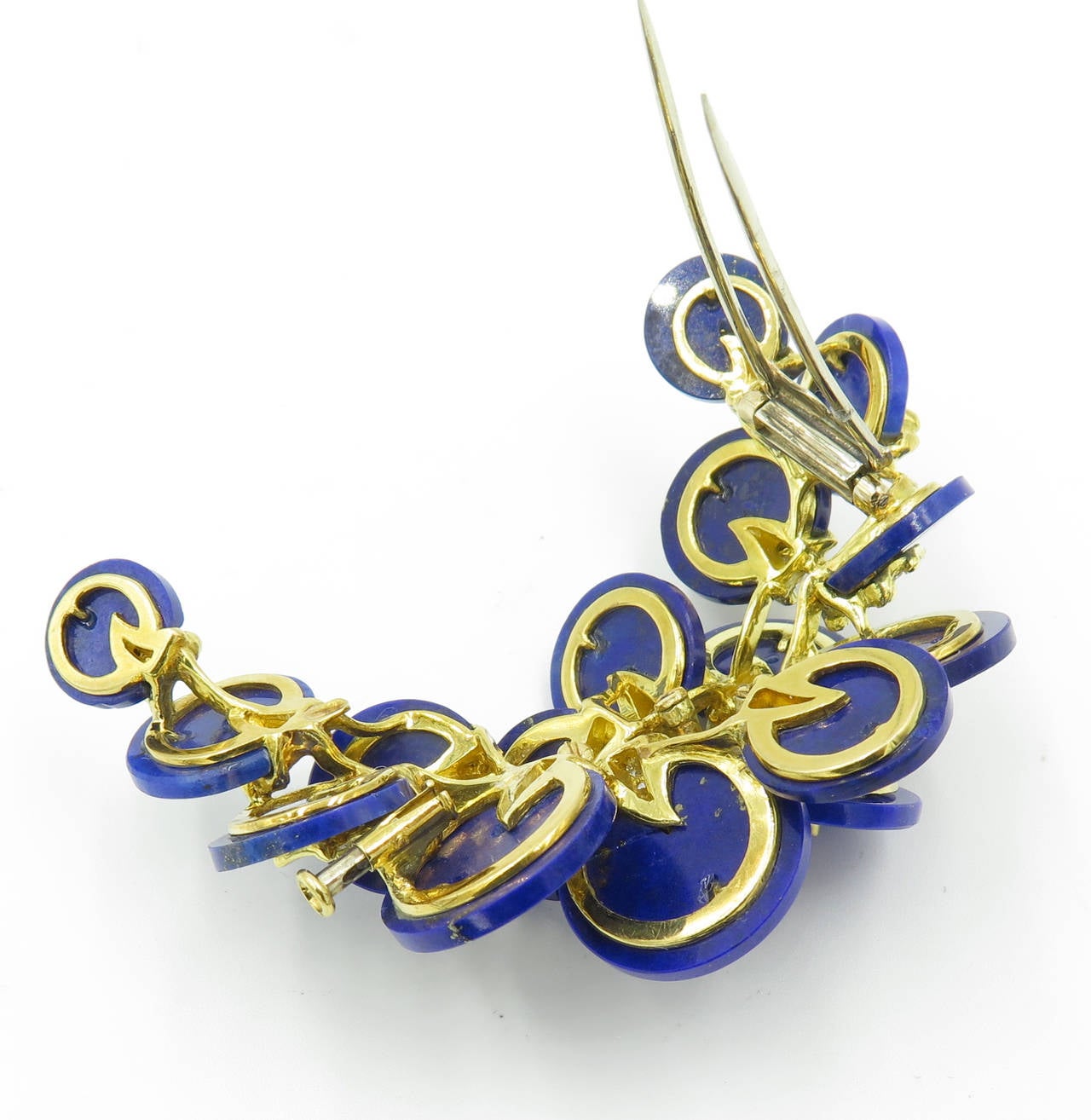 An 18 karat yellow gold, lapis lazuli and diamond brooch, Circa 1970s.  The crescent shaped brooch is set with 16 graduated lapis lazuli discs, each mounted with a pave diamond yellow gold section.  The brooch contains a total of 88 single cut and