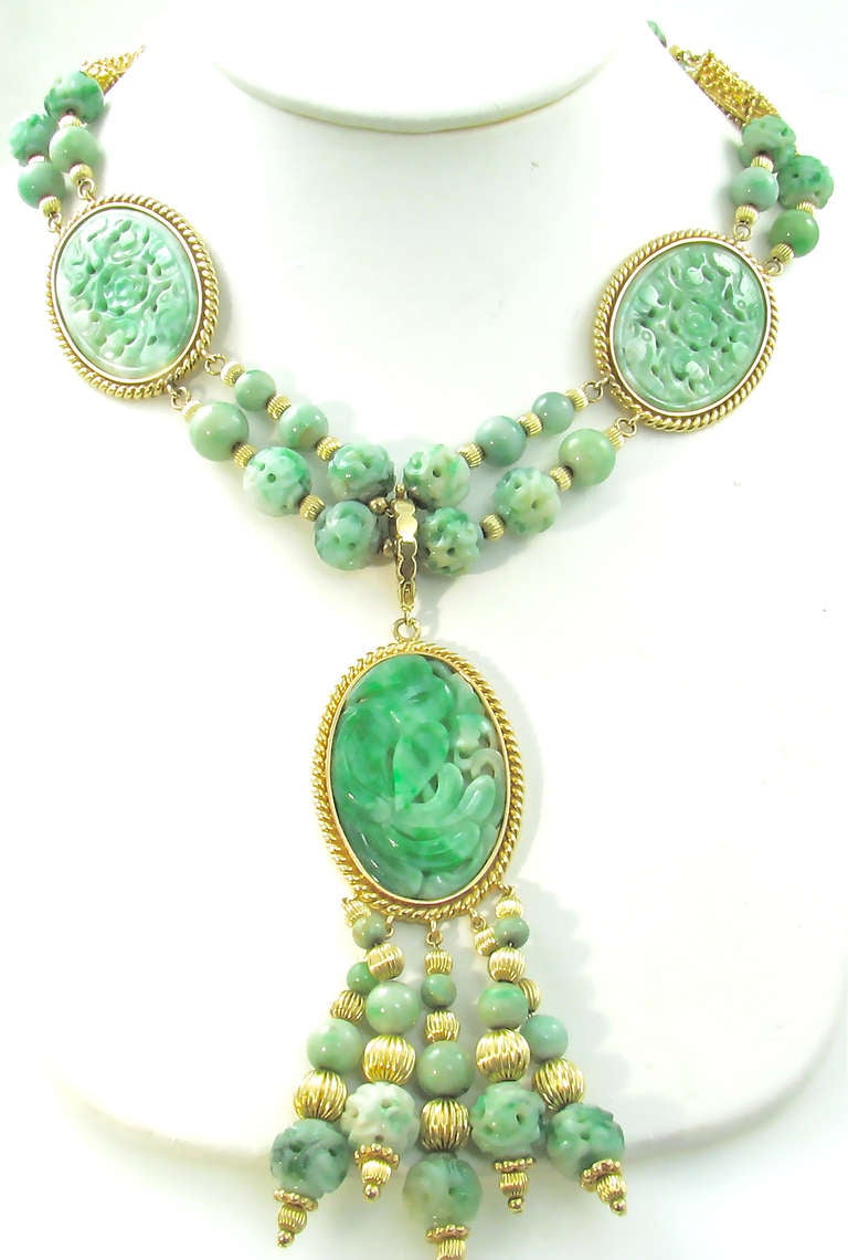 A 14 karat yellow gold and carved jadeite necklace with detachable gold mounted jadeite pendant.  The necklace is circa 1965, the jadeite beads and plaques are circa 1920.  The necklace is designed with two strands of fluted gold beads and 4