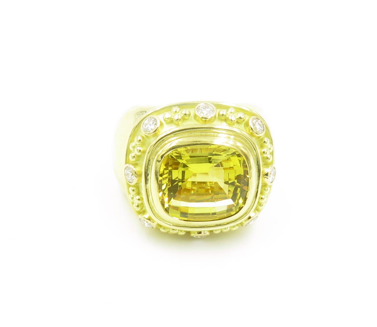An 18 karat yellow gold, golden beryl and diamond “Charlemagne” ring, Elizabeth Gage, London, 2002.  Hallmarked with Elizabeth Gage maker’s mark and London hallmarks.  The ring is bezel set with a cushion shape checkerboard cut golden beryl, and 8