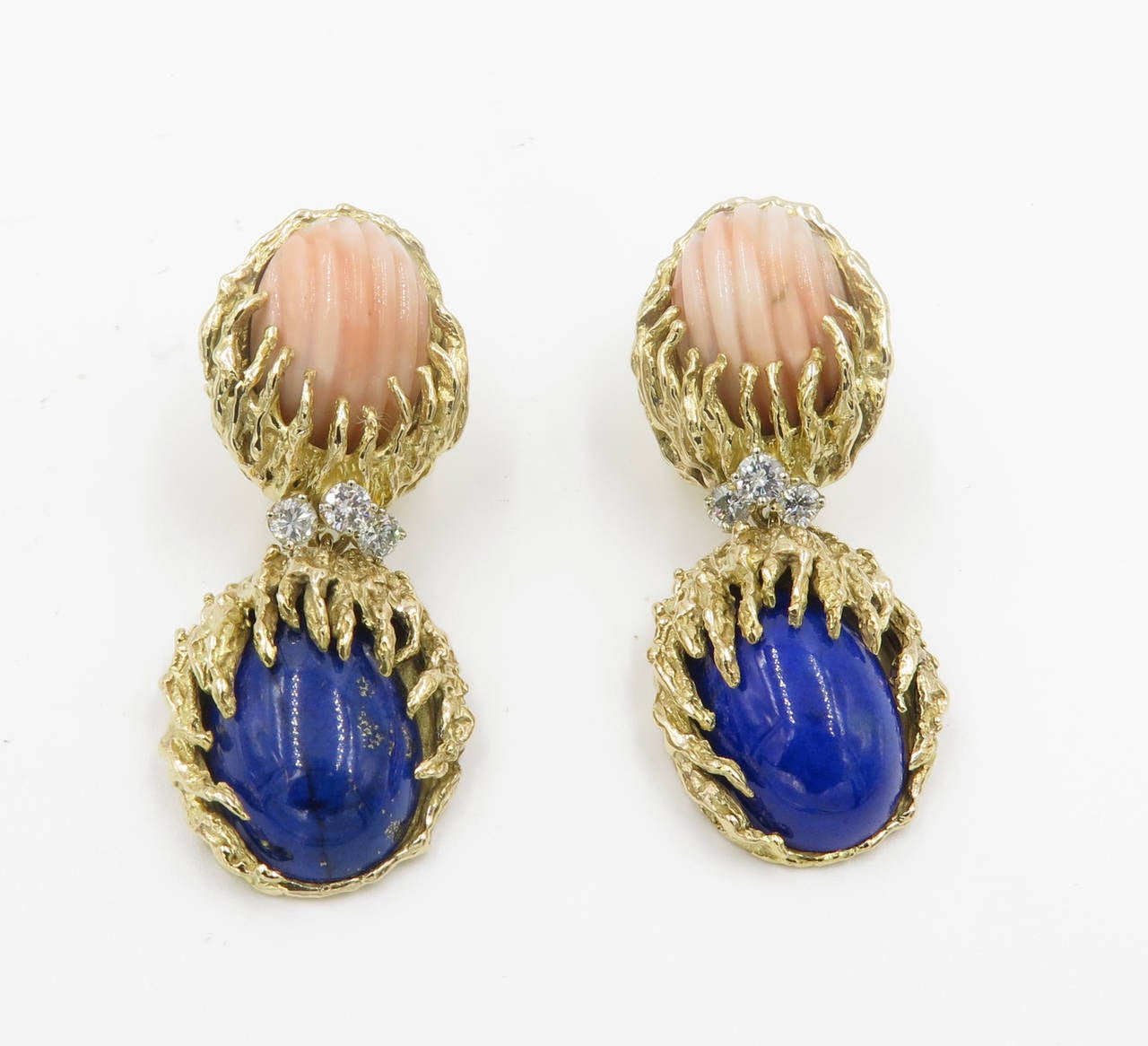 A pair of 14 karat yellow gold, lapis lazuli, coral and diamond earrings, Circa 1960s.  The earrings are designed as a fluted oval cabochon coral suspending a section of 3 diamonds and a cabochon oval lapis lazuli.  The 6 round brilliant cut