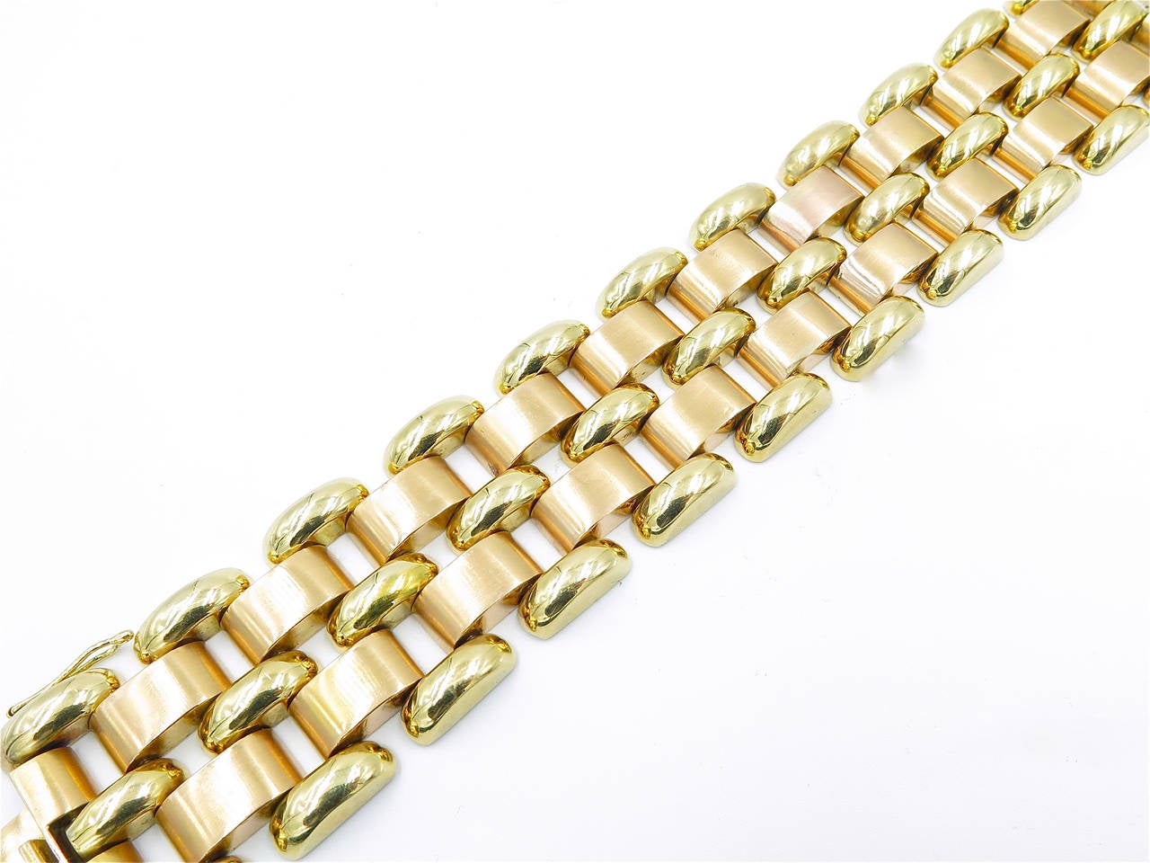 An 18 karat rose and yellow gold bracelet, circa 1940s.  The bracelet is designed as 3 rows of polished yellow gold convex links, alternating with 2 rows of matte rose gold oblong links.  The bracelet has a gross weight of approximately 97.9 grams