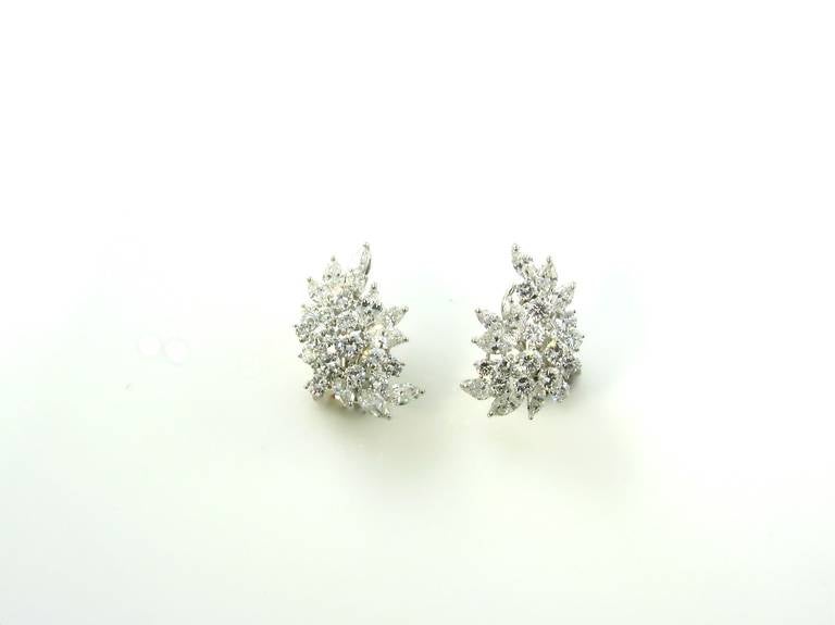 A pair of platinum and diamond crescent leaf cluster form earrings, by Tiffany & Co., Circa 1960.  Signed Tiffany & Co.  The earrings contain a total of 30 round brilliant cut diamonds weighing a total of approximately 4.16 carats, and 18 marquise