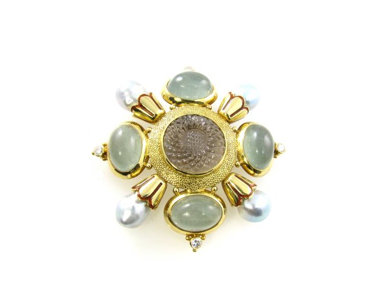 An 18 karat yellow gold, labradorite, smoky quartz, pearl and diamond “Kiss” brooch, Elizabeth Gage, London, 1998.  The brooch is set with 4 cabochon labradorites, a center smoky quartz carved in the form of a sunflower, 4 pearls and 4 round
