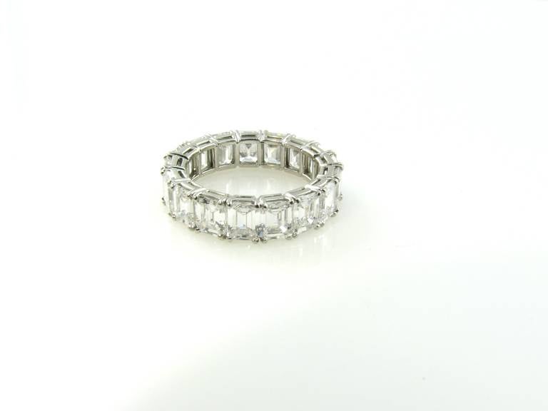 A platinum and diamond eternity band ring, by Harry Winston.  Unsigned, with copy of letter from Harry Winston.  The ring is designed as continuously set 17 emerald cut diamonds weighing 6.93 carats of approximately F color and VS clarity.  Note: 
