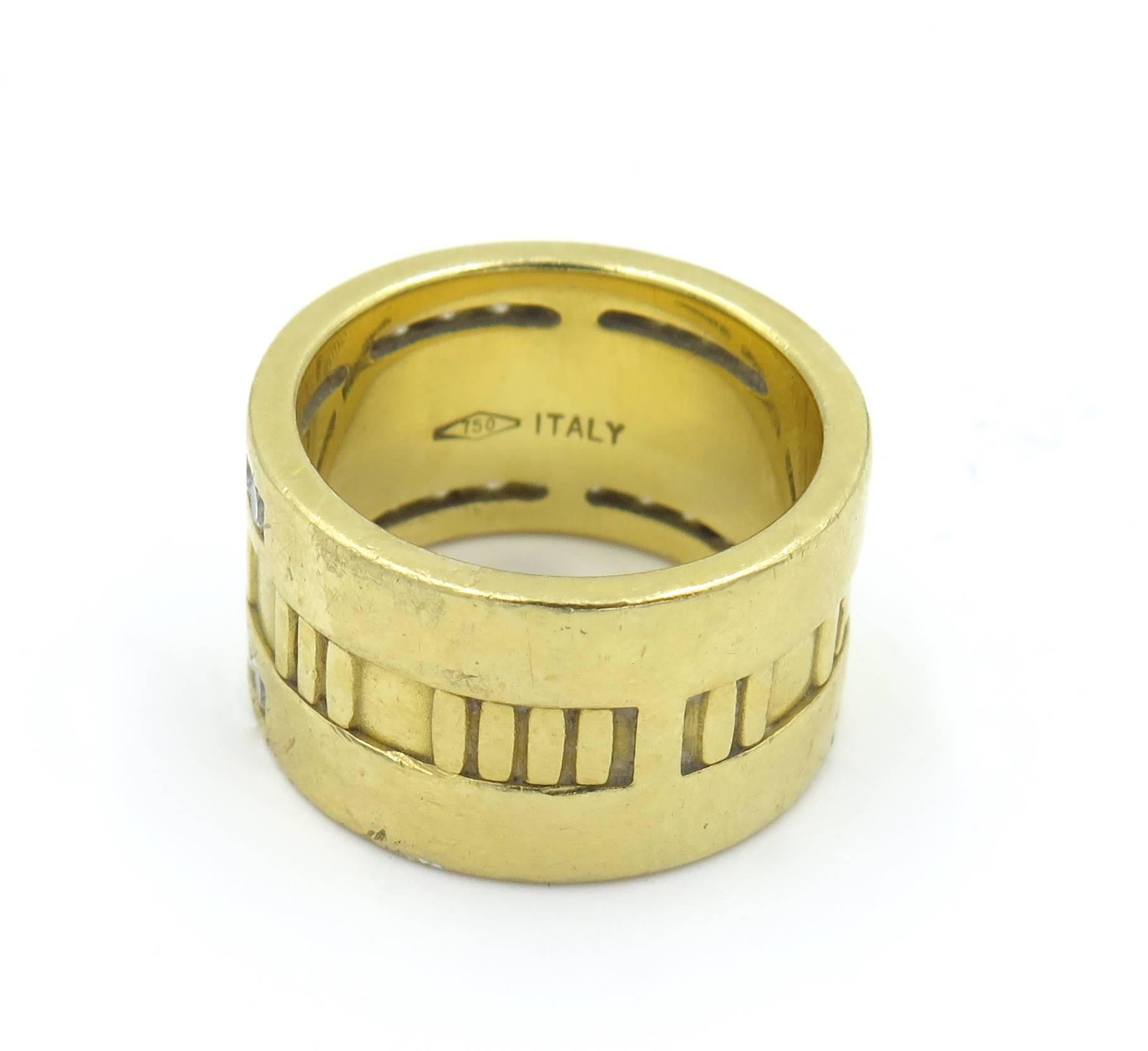 An 18 karat yellow gold and diamond “Atlas” band ring, signed Tiffany & Co., 1995. Designed as a wide gold band, decorated with Roman numerals, the top enhanced by channel-set circular-cut diamonds. (30) circular-cut diamonds, weighing approximately