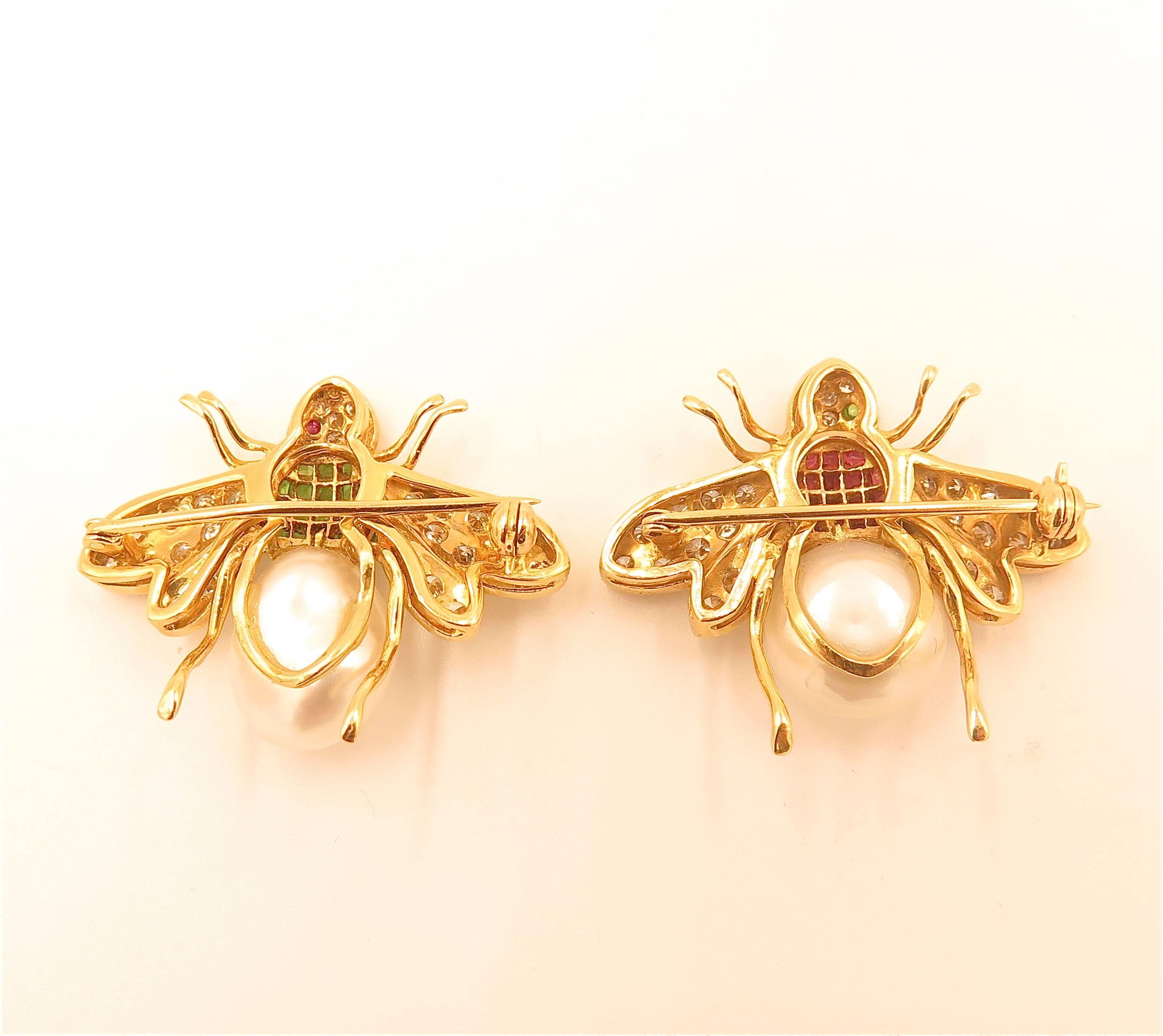 A pair of emerald, ruby, diamond, and pearl bee brooches. 18k. 26 diamonds on each bee (22 on wings and 4 on head). 1 bee has cabochon ruby eyes and 18 emeralds. 1 bee has cabochon emerald eyes and 18 rubies. Pearl makes up body of bee. 