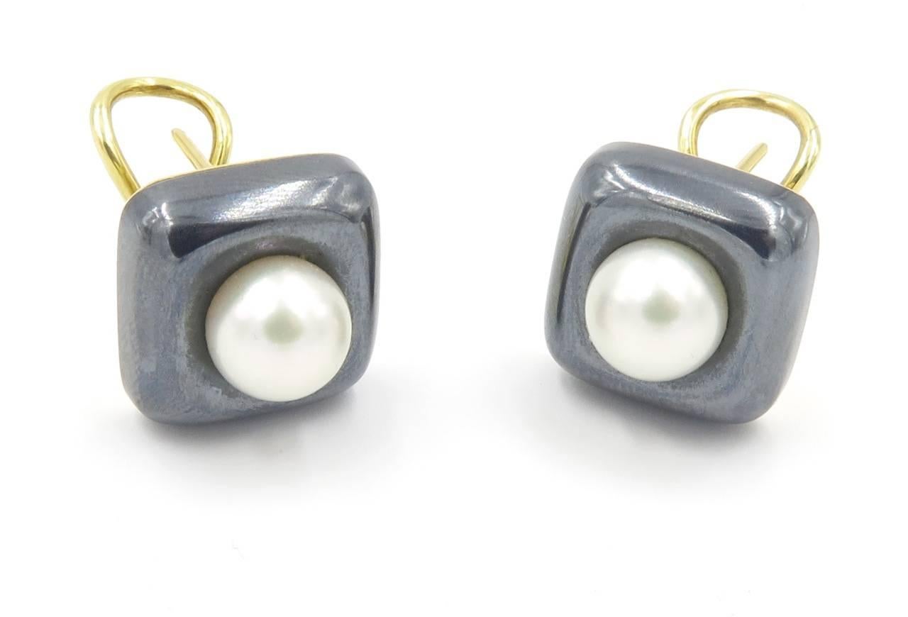 A pair of 18 karat yellow gold, hematite and pearl earrings, Angela Cummings, ©1984. Designed as a carved square cushion hematite, centering a white cultured pearl, measuring approximately 8.00mm. Length 1/2 inch. Gross weight is approximately 16.1