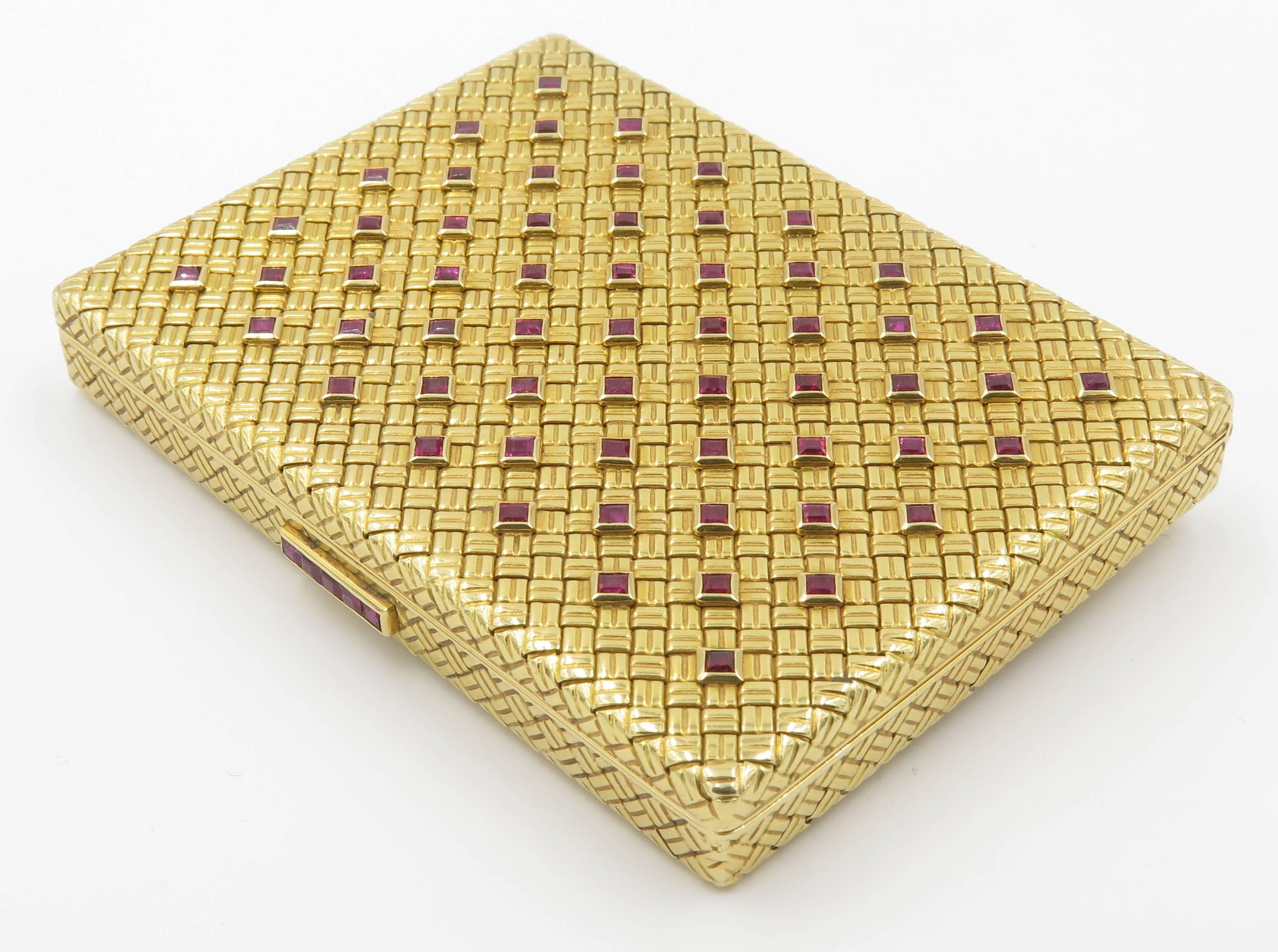 An 18 karat yellow gold and ruby compact, Van Cleef & Arpels, Circa late 1950's.  The rectangular case of basket weave design, enhanced by square-cut rubies. Opening to reveal a mirror and powder compartment. Measures 3 x 2 1/4 x 3/8 inches. Gross