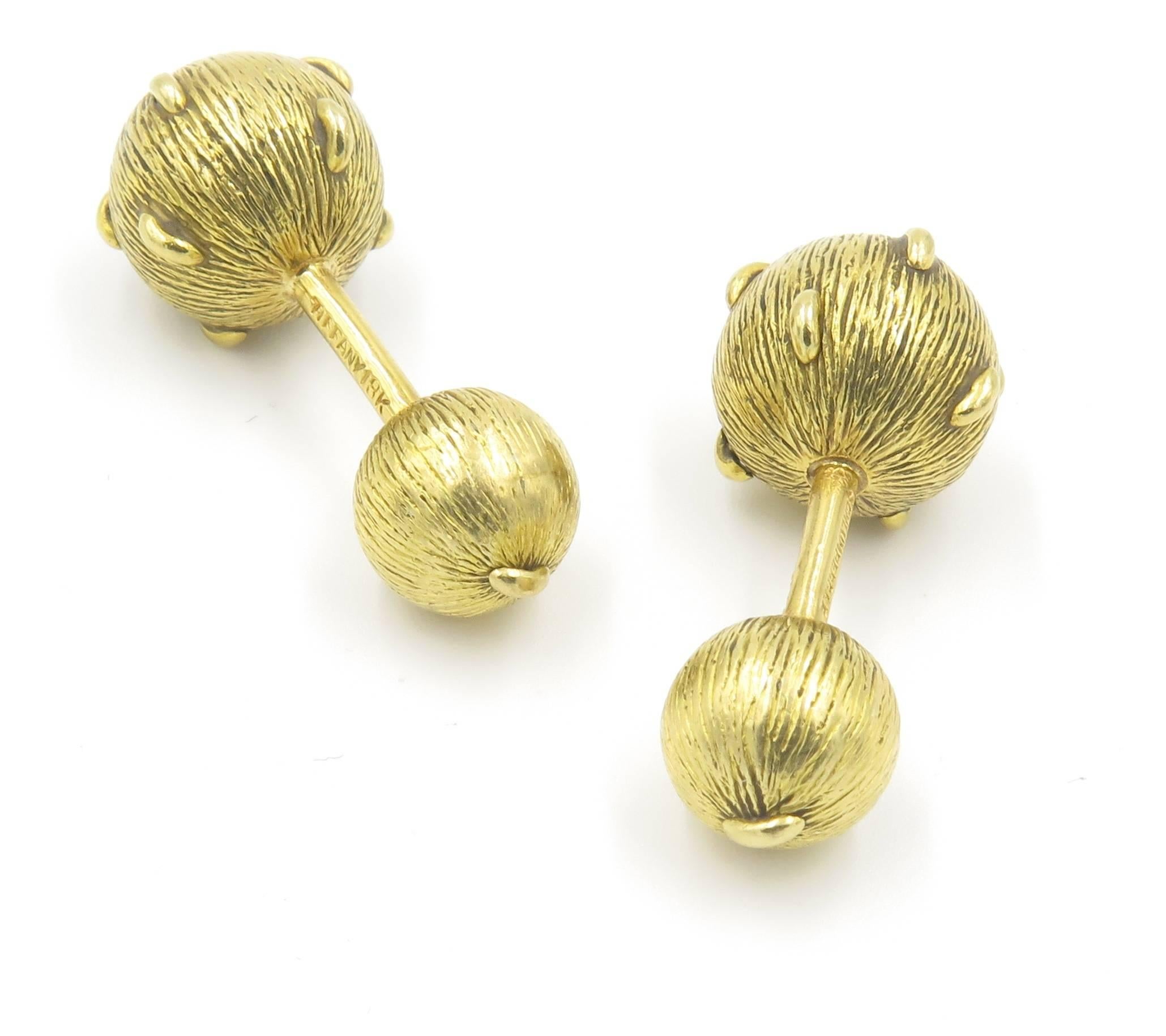 A pair of 18 karat yellow gold cufflinks, Tiffany & Co. Schlumberger. Circa 1990. Each double link set with a textured gold sphere. Diameter of largest link is 1/2 inch. Signed Tiffany, 18K. Schlumberger. Gross weight is approximately 14.4 grams.