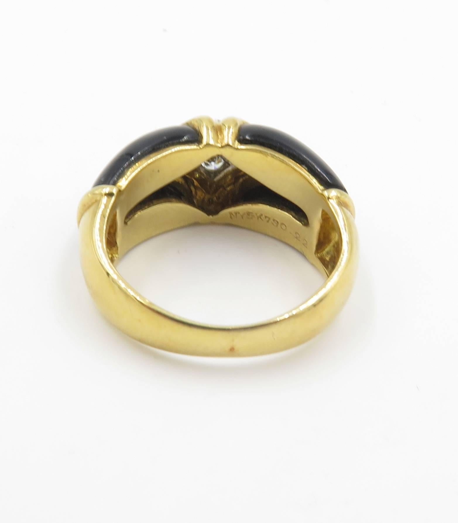 An 18 karat yellow gold, black onyx and diamond ring.  Van Cleef & Arpels.  Of bombe' design, set with onyx, centering a navette-shaped pave' diamond panel, enhanced by polished gold lines.  Four (4) diamonds weigh approximately.  Signed V.C.A. 18K.