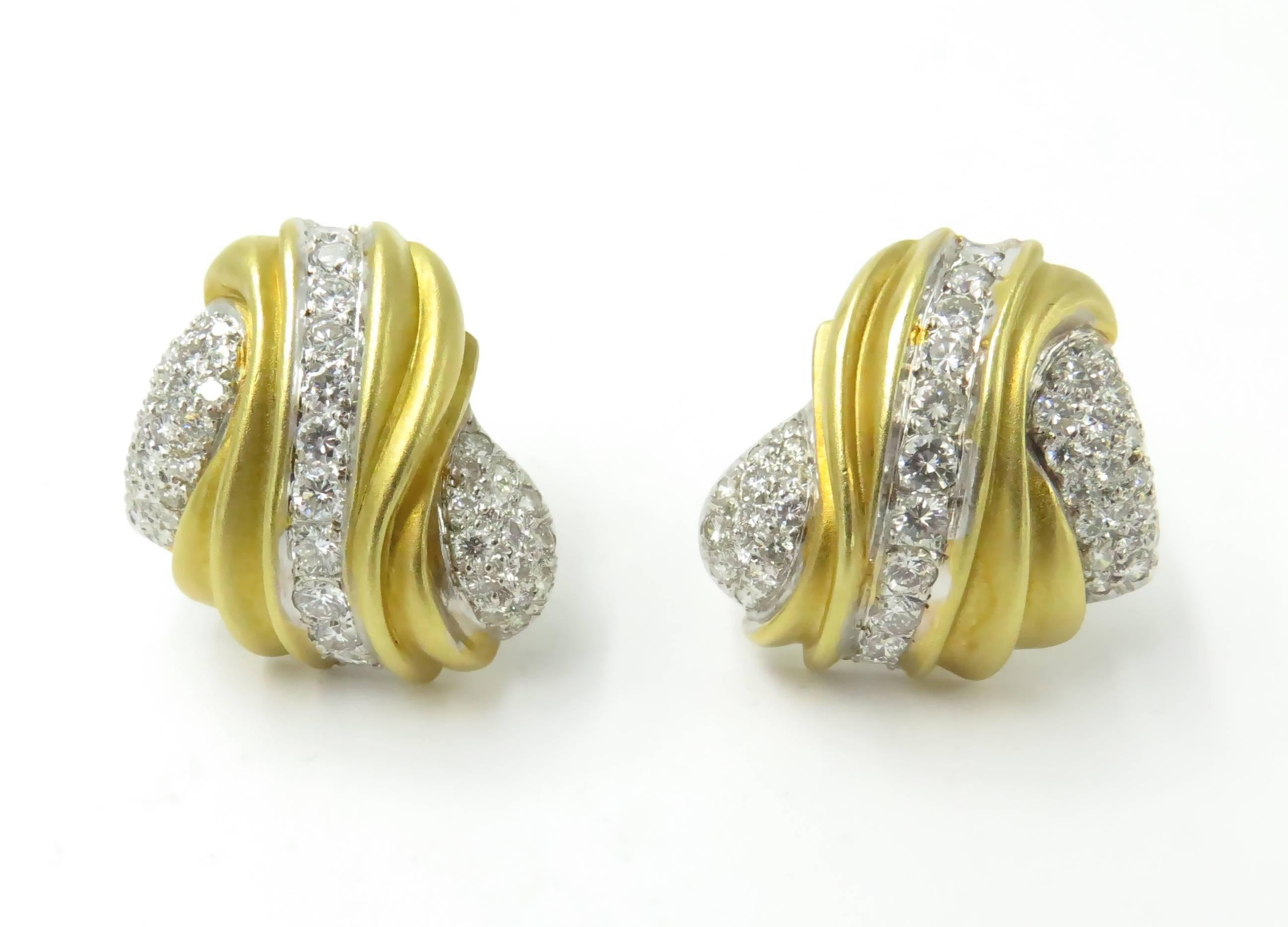 A pair of 18 karat yellow gold and diamond earrings. Circa 1990. Each designed as a matte gold fluted scroll, enhanced by pavé-set diamonds. One hundred  diamonds, weigh approximately 1.88 carats, G/H color, VS clarity. Length is 1 inch. Gross