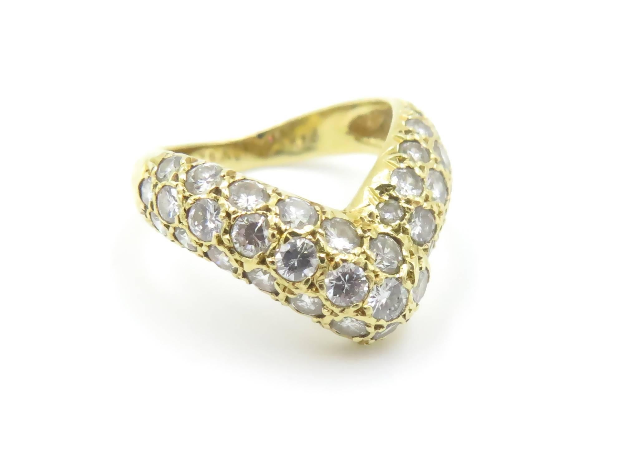 An 18 karat yellow gold and diamond ring.  Van Cleef & Arpels.  1979.  Designed as a pavé -set band of V design. Thirty Five (35) diamonds weigh approximately 1.40 carats.  Gross weight approximately 5.1 grams. Stamped VCA © 79 F (indistinct) 18K.