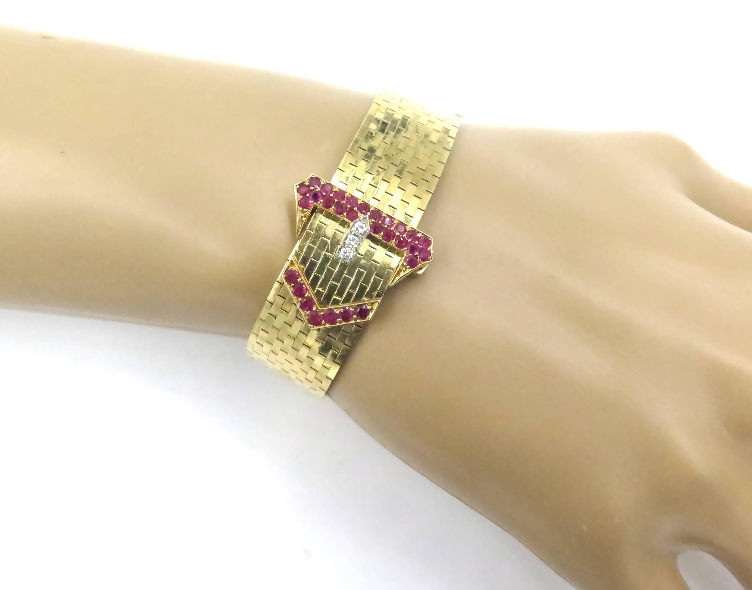 A 14 karat yellow gold, ruby and diamond buckle style bracelet.  Tiffany & Co.  Circa 1940.  Deigned as a polished gold band, enhanced by a circular-cut ruby and diamond buckle. Stamped Tiffany & Co, 14K, numbered 807. Length is adjustable. Gross