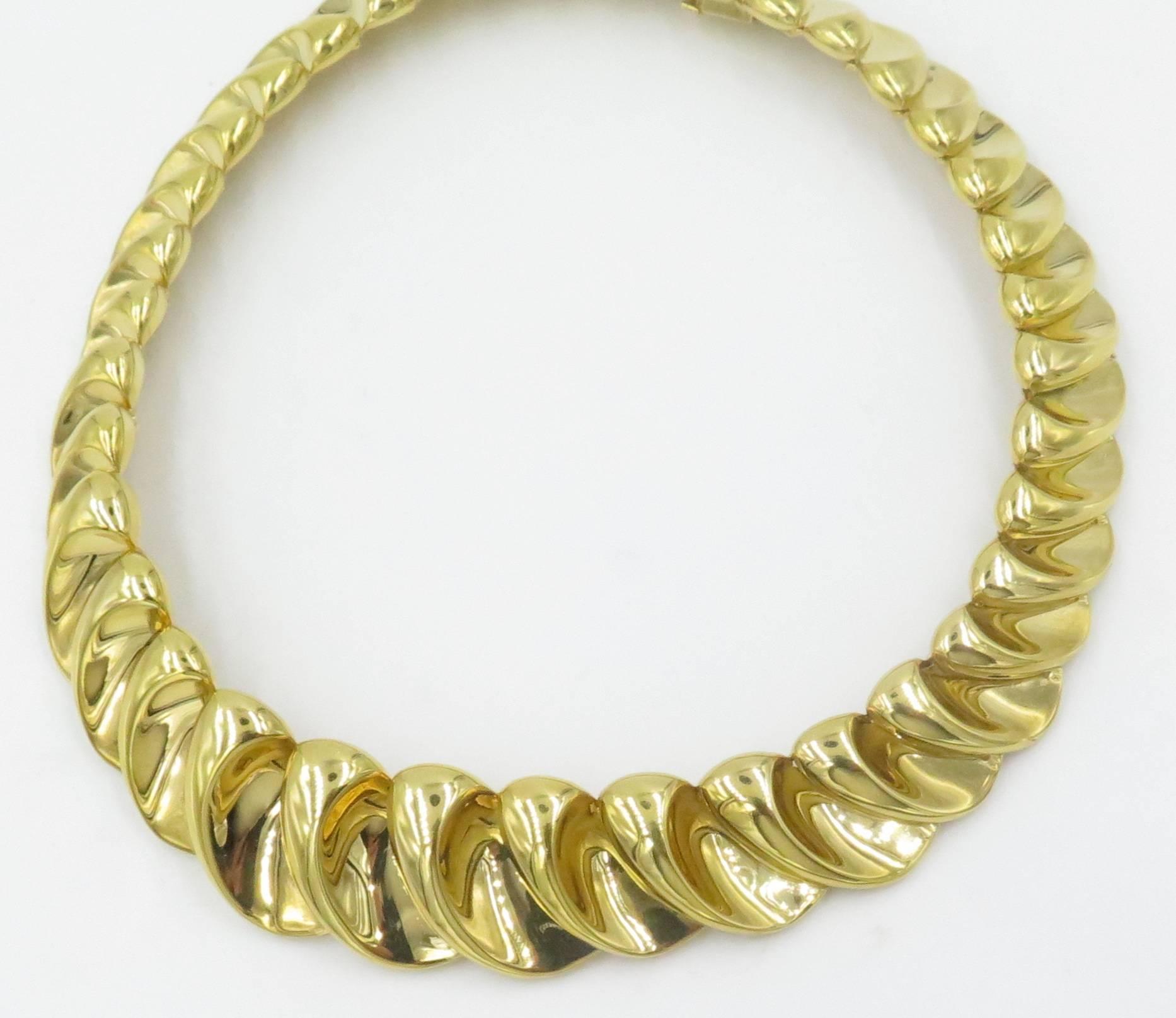 An 18 karat yellow gold necklace.  Circa 1970.  The collar designed as a line of graduated polished gold crescent shaped links. Length is 14 inches.  Gross weight approximately 119.9 grams