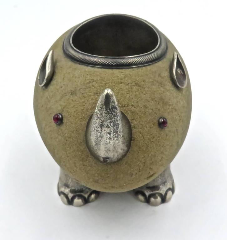 A Russian Gem-Set Silver Mounted and Sandstone Match Holder in the Form for a Rhinoceros. Marked Faberge', with the workmasters mark of Julius Rappoport, St. Petersburg, Circa 1890. Scratched inventory number indistinct.
Ovoid, the sandstone body