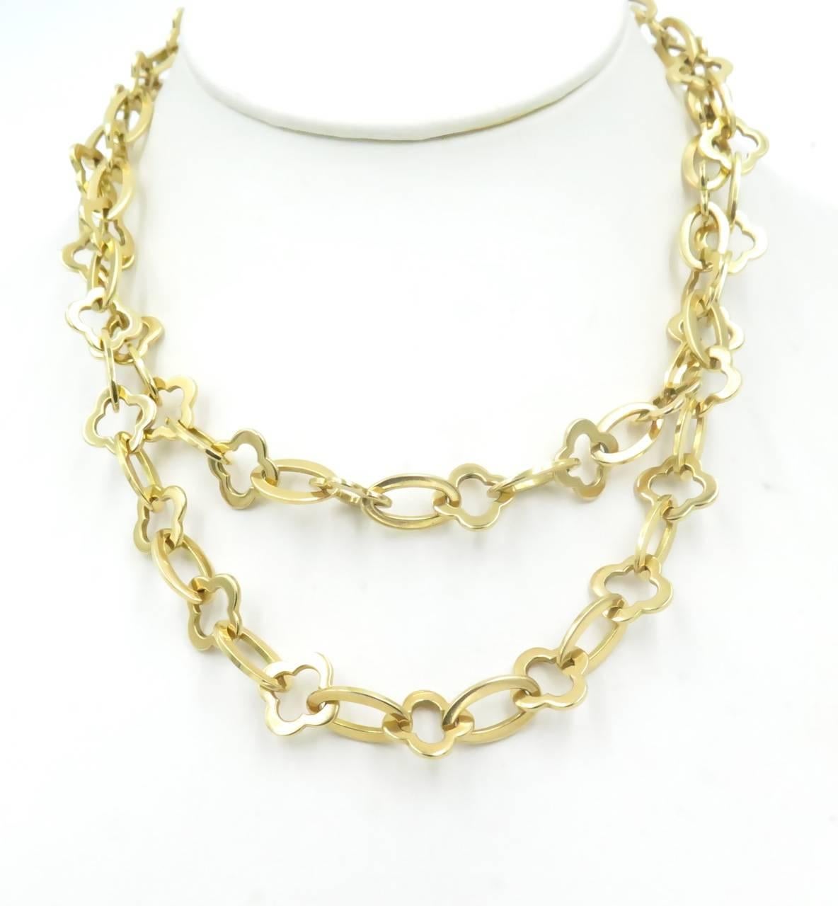 An 18 karat yellow gold Byzantine Alhambra long chain necklace.  Van Cleef & Arpels.  Circa 1990.  Designed as a series of polished gold openwork Alhambra links, spaced by polished gold oval links.  Length is approximately 31 1/2 inches. Gross