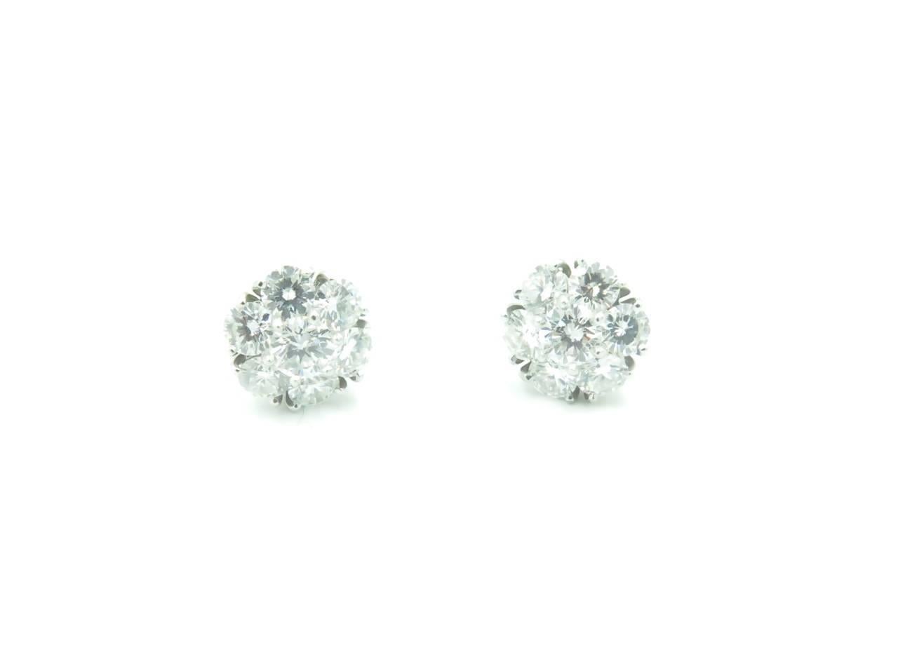 A pair of 18 karat white gold and diamond Large Fleurette earrings. Van Cleef & Arpels. Fourteen (14) diamonds weigh approximately 1.88 carats. D,E,F color IF-VVS clarity. Stamped VCA , numbered NY64936.