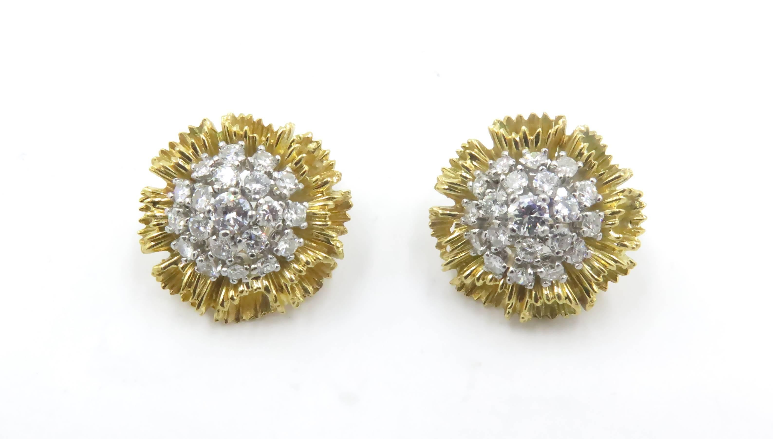 A pair of 18 karat yellow gold and diamond earrings.  Circa 1960s.   Designed as a flowered, centering a circular-cut diamond cluster, extending textured gold petals. Forty (40) diamonds weigh approximately 2.40 carats.Gross weight approximately