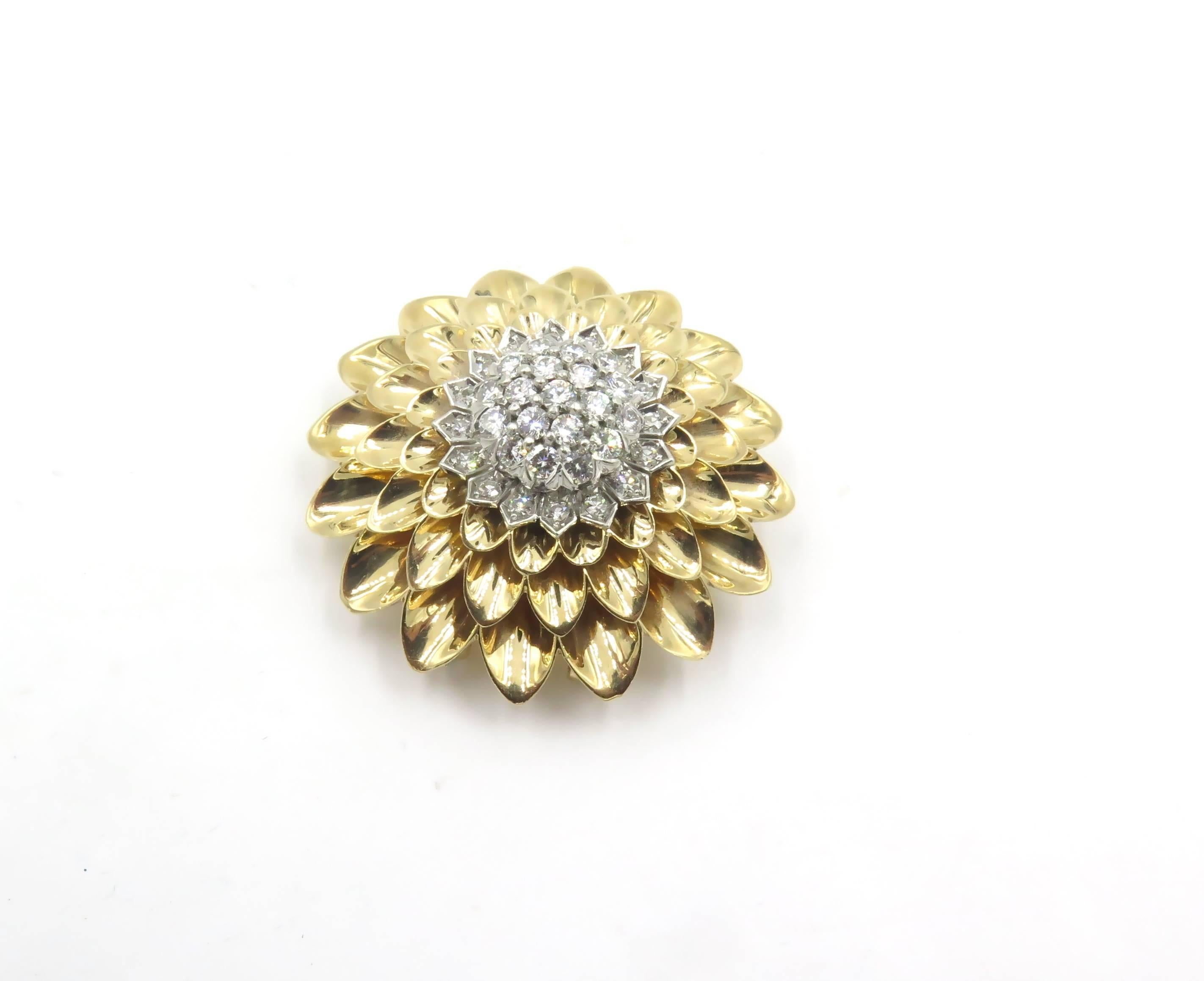 A 14 karat yellow gold and diamond brooch.  Tiffany & Co.  Circa 1950. Designed as a polished gold chrysanthemum, centering a cluster of circular cut diamonds,. Thirty four (34) diamonds weigh approximately 1.40 carats. Diameter is approximately