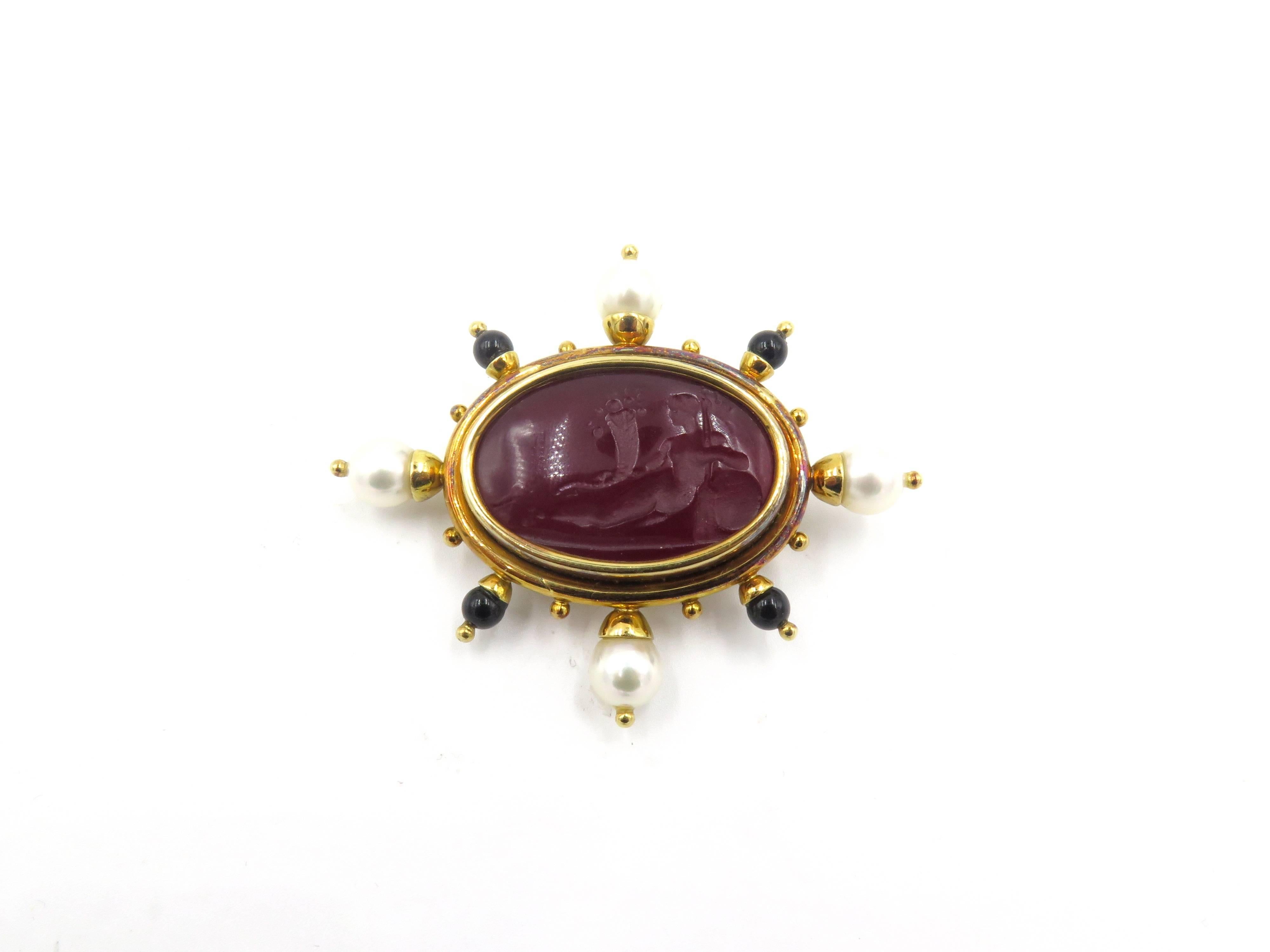 An 18 karat yellow gold, red Venetian glass, mother of pearl, cultured pearl and onyx brooch. Elizabeth Locke. Set with an oval red Venetian glass intaglio depicting the goddess Demeter, backed by mother of pearl, within a polished gold surround,