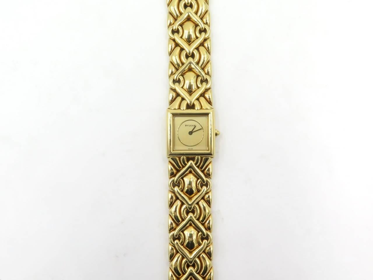 A ladies 18 karat yellow gold Trika watch.  Bulgari. Of quartz movement,  with a square gold tone dial, joined by a flexible polished gold bracelet of woven geometric design. Length of watch is approximately 6 1/2 inches. Gross weight is