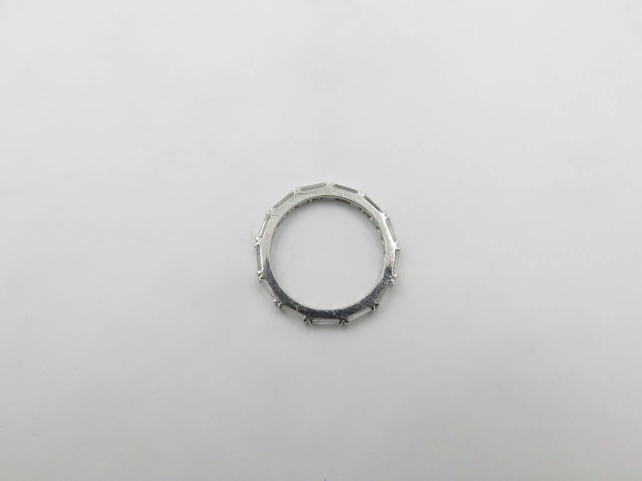 A platinum and diamond ring.  The eternity style band has (13) baguette shape diamonds set in a platinum split bar mounting.  Total diamond weight approximately 1.06 carats, 2mm in width.  Gross weight approximately 2.4 grams.  Size 5.