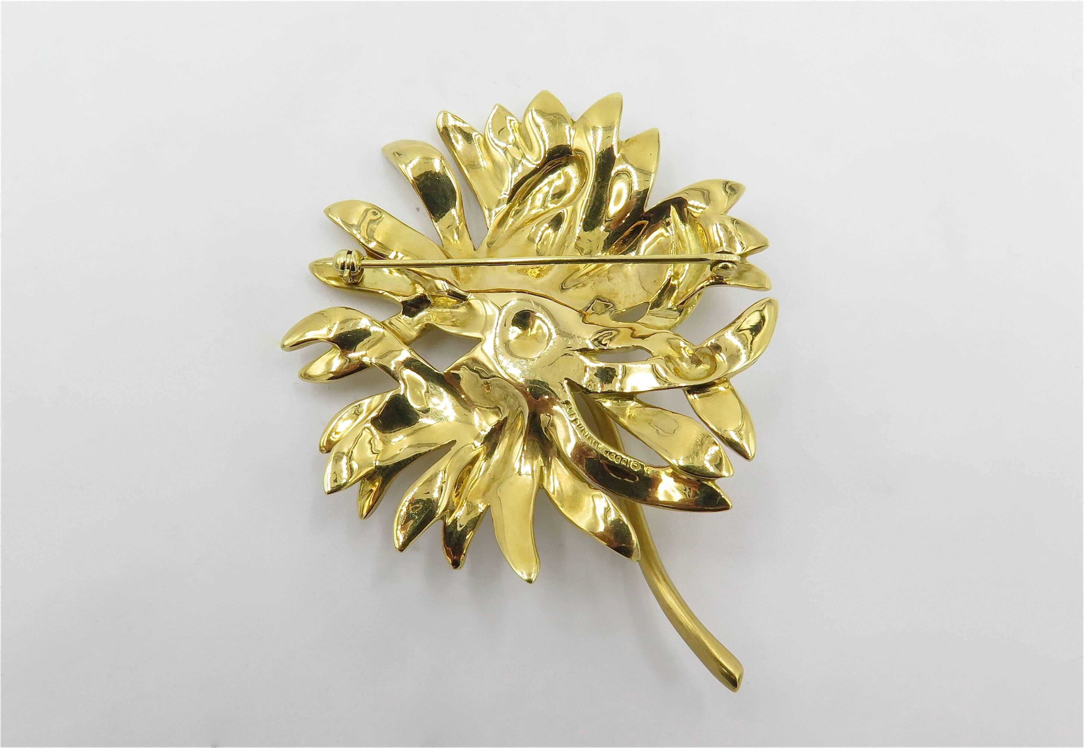An 18 karat yellow gold brooch. Angela Cummings. Designed as a textured gold reverse textured gold chrysanthemum, with polished gold stem. Length is approximately 2 3/4 inches. Gross weight is approximately 36.4 grams. Stamped Cummings 18K, 1989. 
