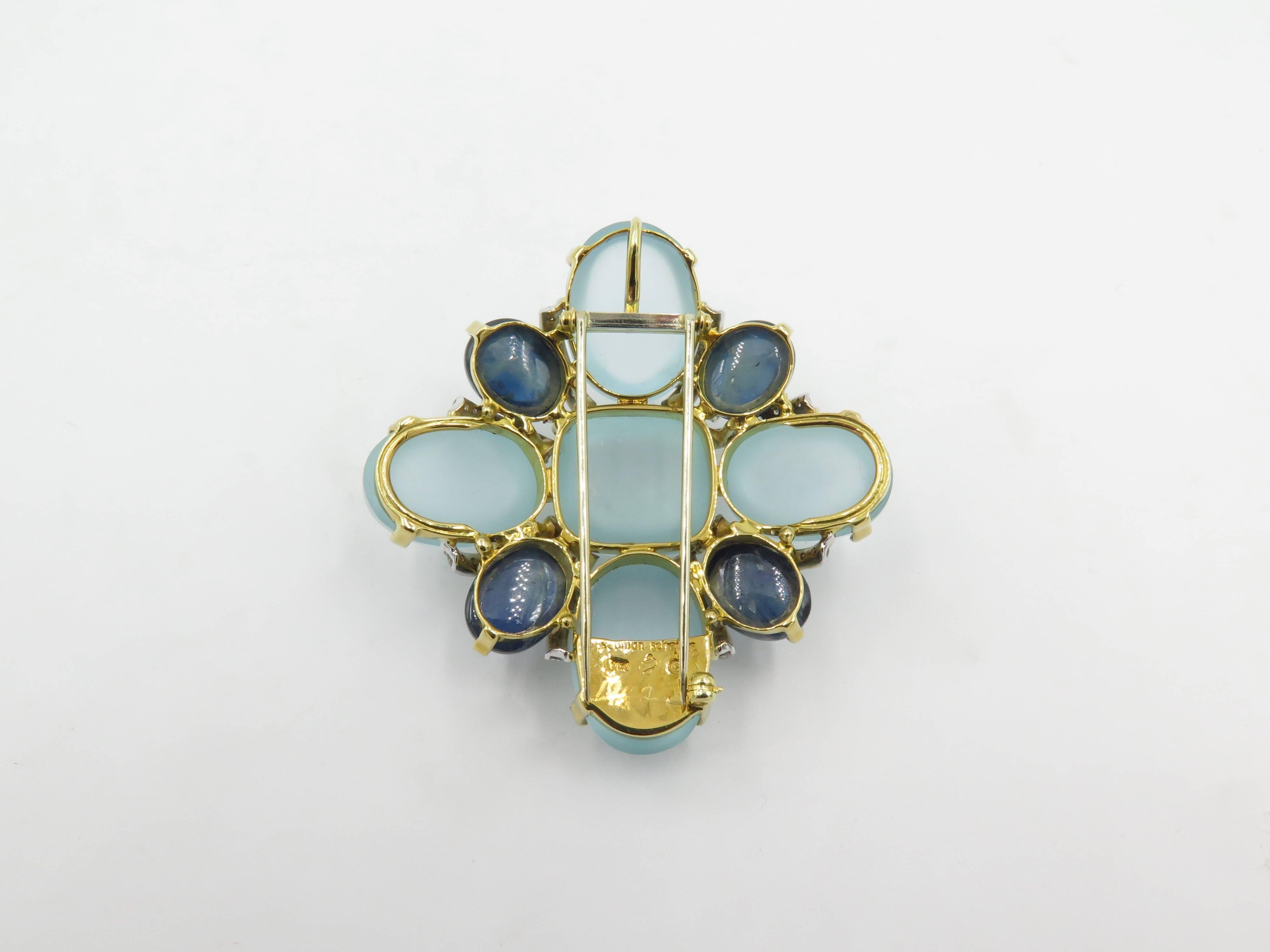 An 18 karat yellow gold, aquamarine, sapphire and diamond brooch.  Seaman Schepps.  The stylized Maltese cross motif is set with (5) cabochon milky aquamarines ( (4) four oval and (1) one cushion shape), (4) four oval cabochon sapphires and (48)