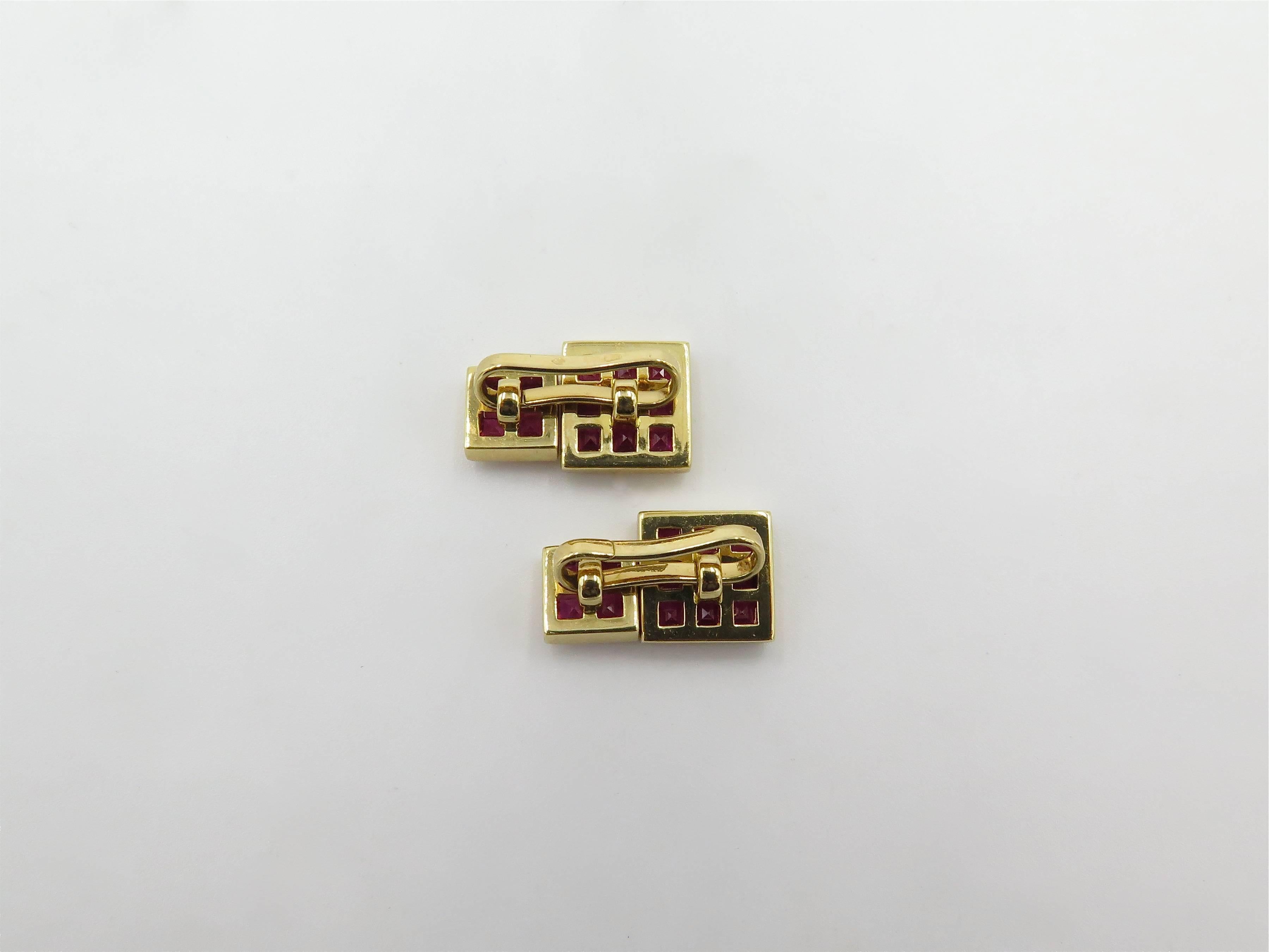 A pair of 18 karat yellow gold and ruby cufflinks. French. Circa 1980. Each designed as a larger and smaller square plaque, set with square cut rubies, spaced by an openwork bar link. Twenty six (26) rubies weigh approximately  1.80 carat.  Larger
