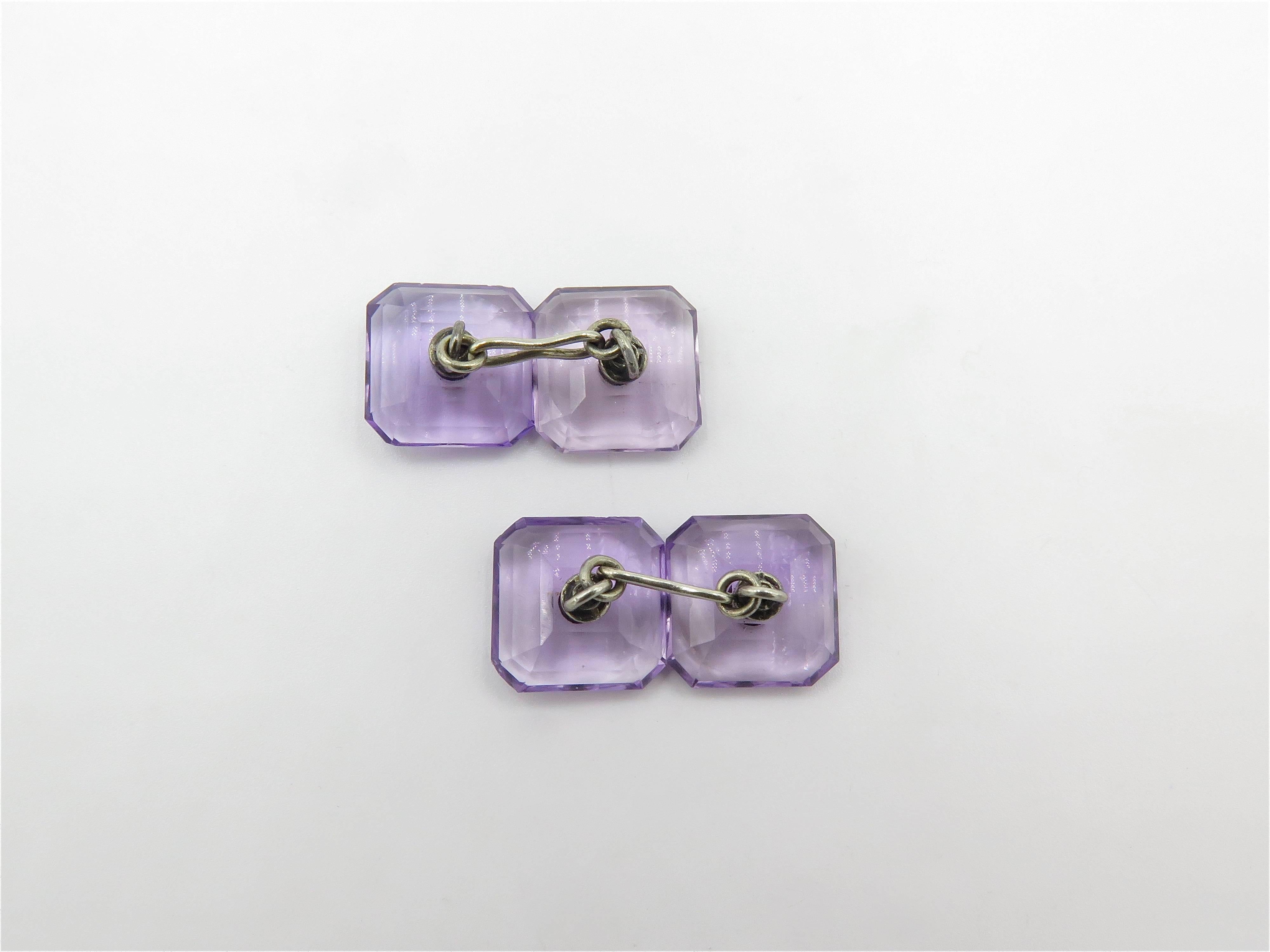 A pair of 18 karat white gold, amethyst and diamond cufflinks. Circa 1930. Each double link set with square faceted amethyst plaque, measuring approximately 13.00mm, centering a circular cut diamond. Gross weight is approximately 7.0 grams. 
