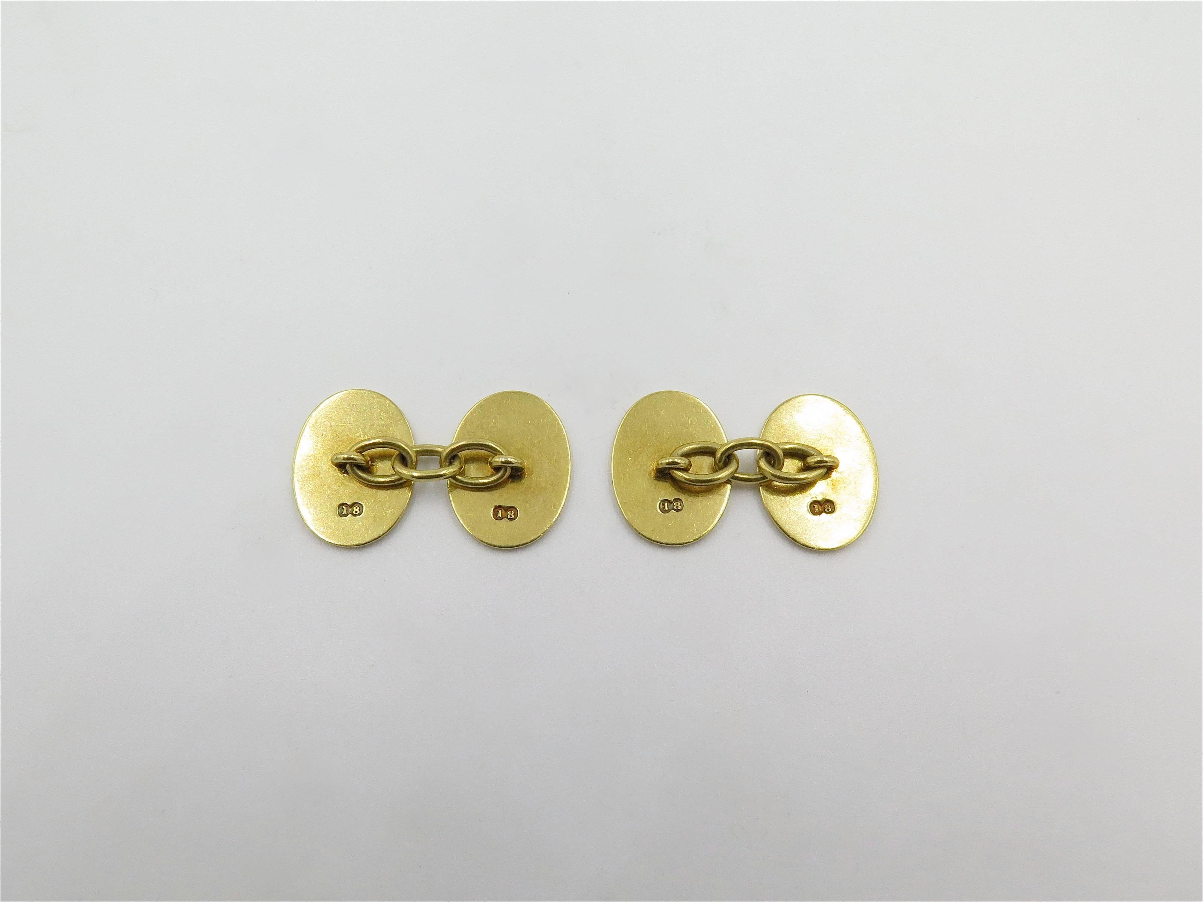 A pair of 18 karat yellow gold and enamel cufflinks. English. Each double link designed as an oval gold plaque, decorated with red, white and yellow enamel crests, celebrating the anniversary of the coup d'etat in Yugoslavia and the accession of