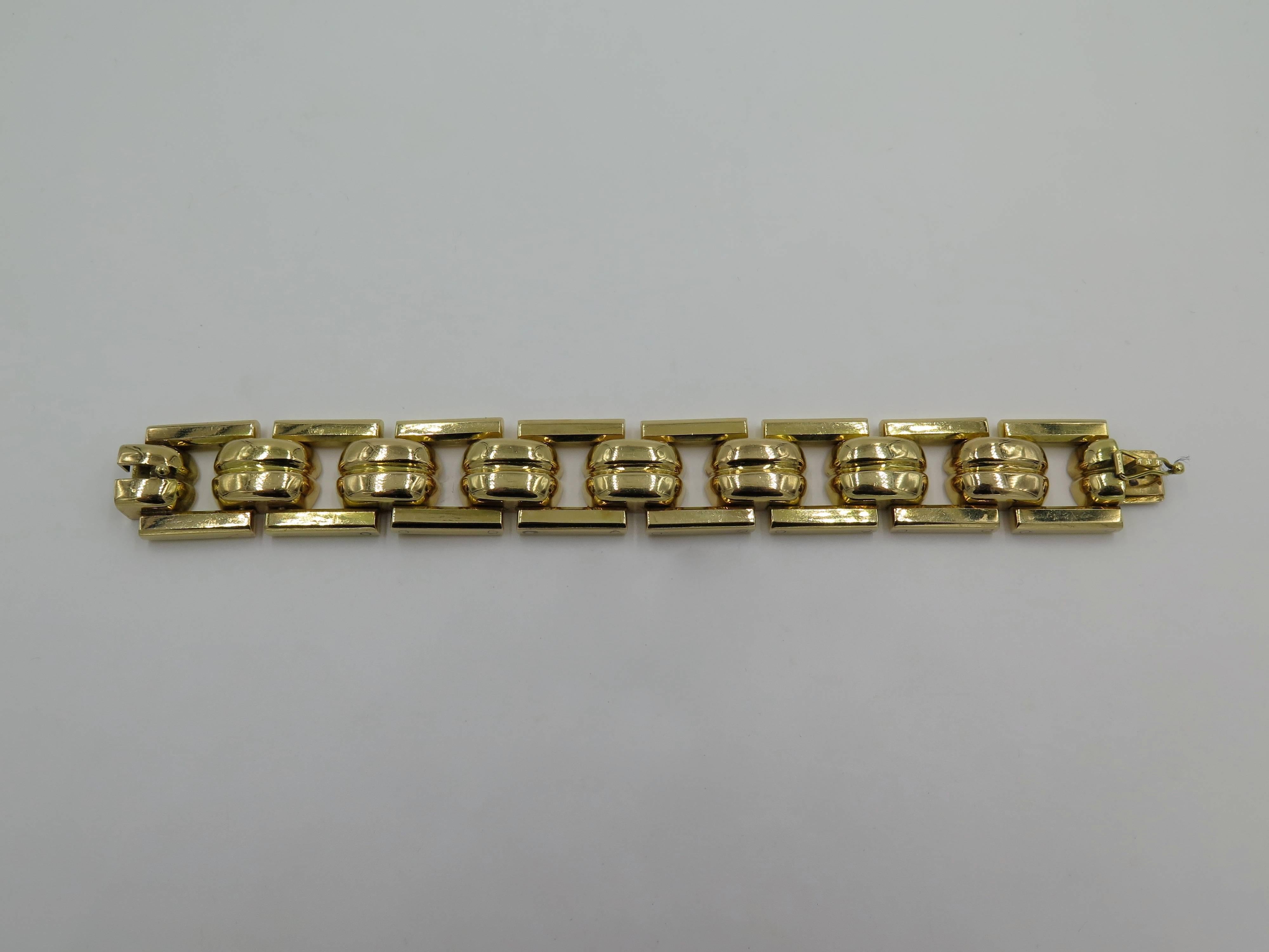 An 18 karat yellow gold bracelet.  Circa 1940.  Designed as a series of rectangular shaped links, spaced by solid curb shaped links. Length is approximately 6 1/2 inches. Gross weight is approximately 125.5 grams.