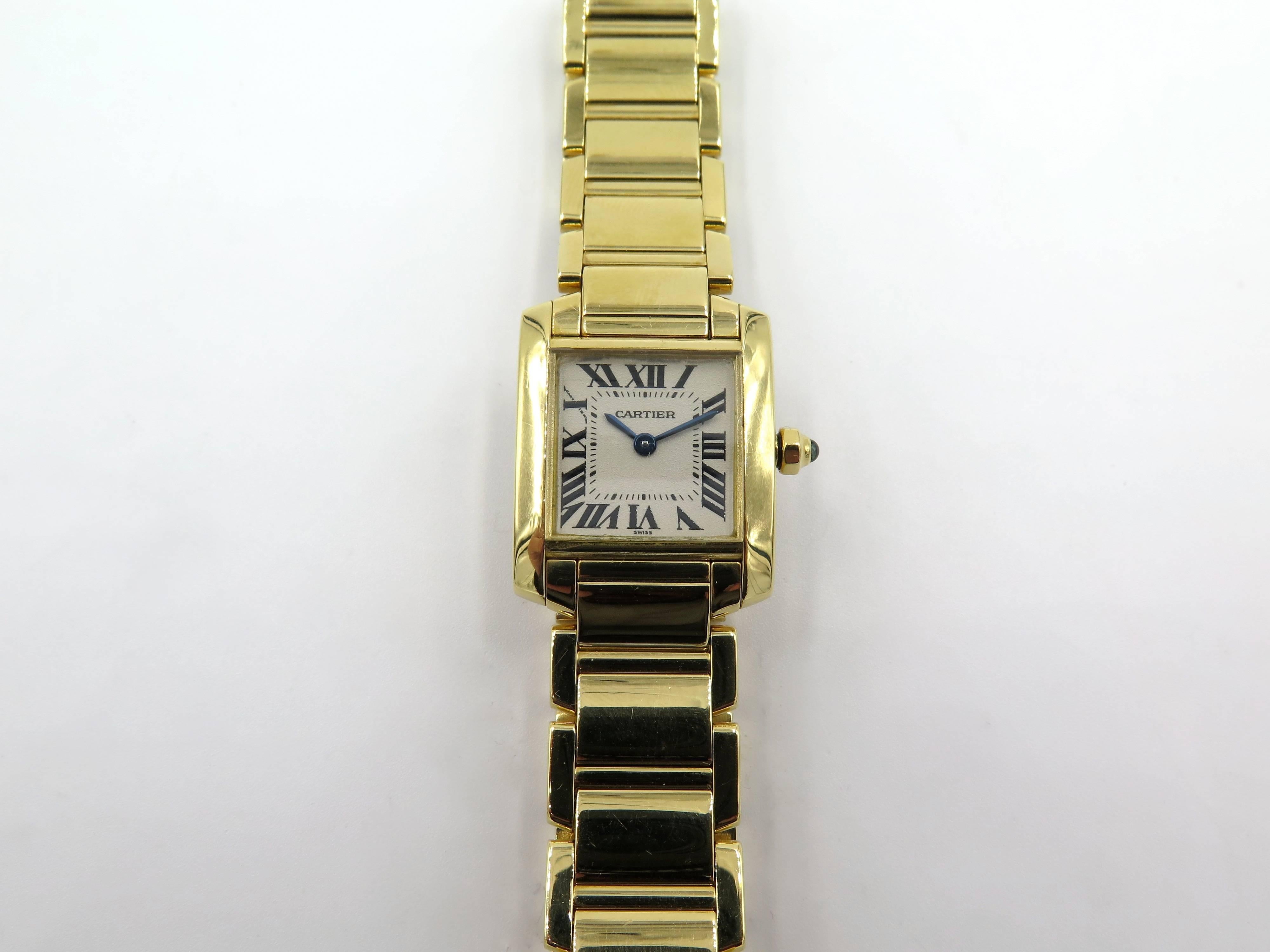 A ladies 18 karat yellow gold Cartier Tank Francaise watch.  18K yellow gold 20mm x 23mm Cartier Tank Française watch featuring a quartz movement, smooth bezel, flat ivory dial, 18K yellow gold link bracelet , sapphire crown and  double deployant