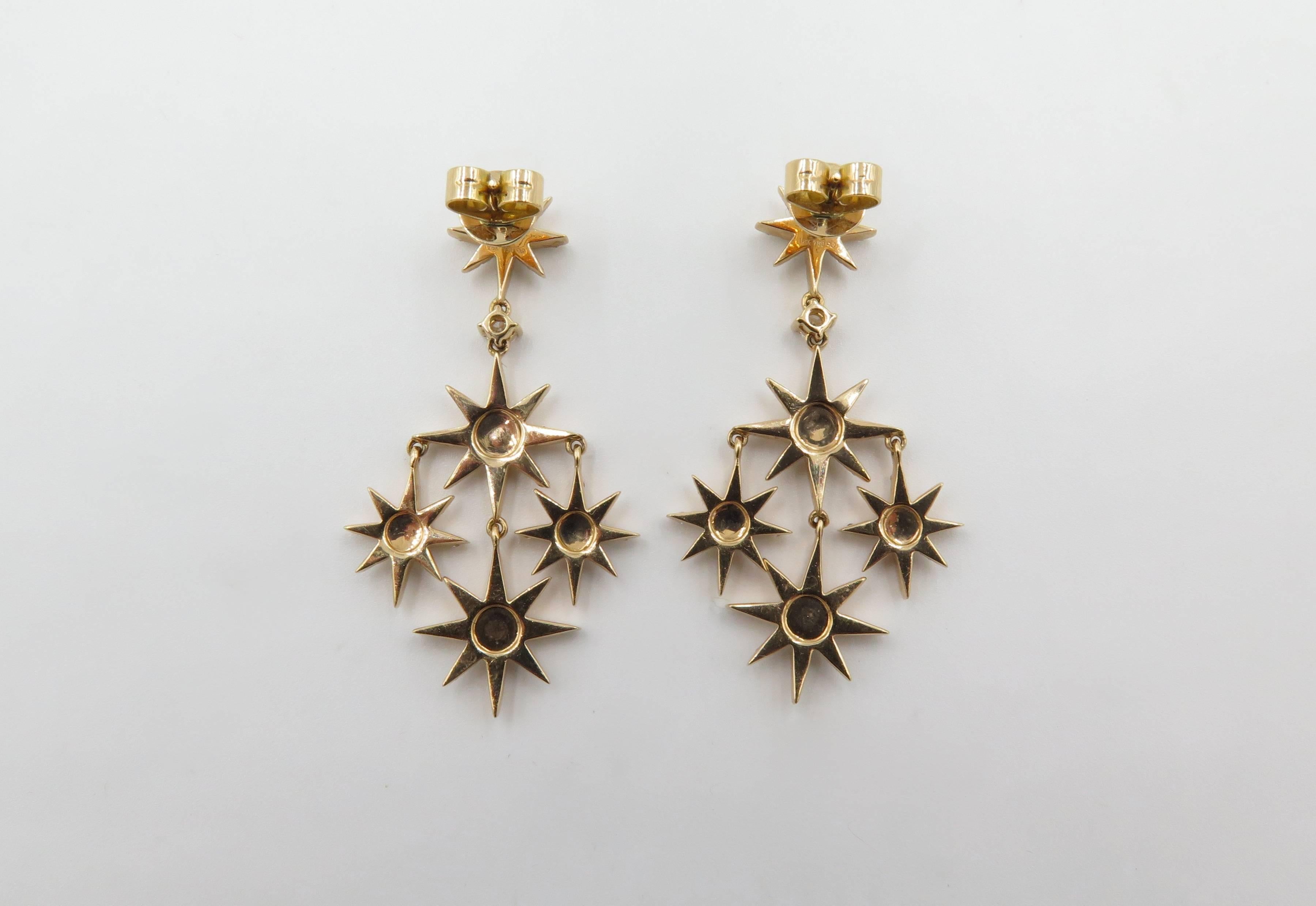 A pair of 18 karat rose gold and diamond pendant earrings with post and friction backs.  Each earring suspends four diamond-set eight point stars in a cross array from a prong-set diamond, further suspended from a diamond-set eight point star.  Each