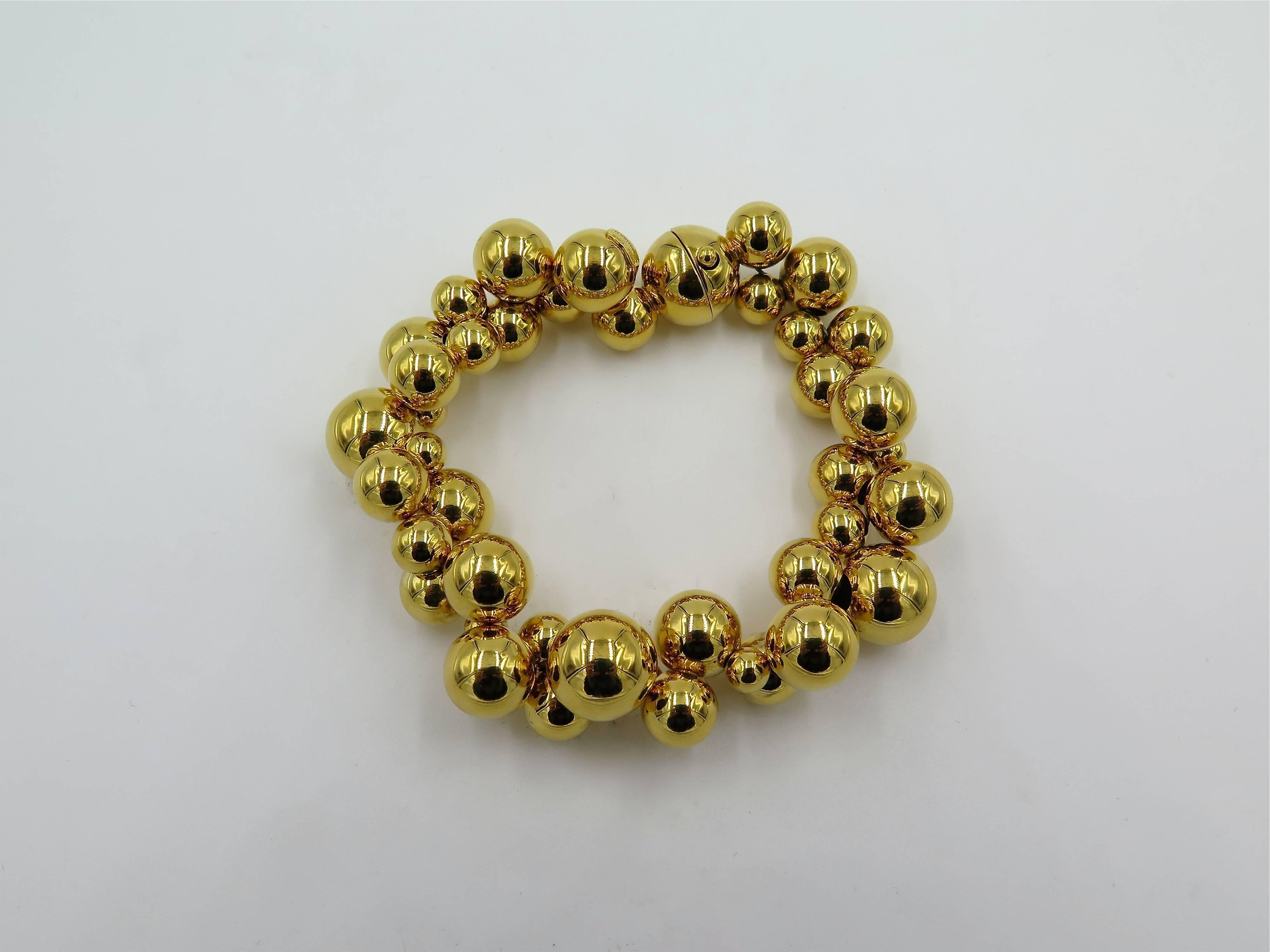 An 18 karat yellow gold Atomo bracelet. Marina B. Designed as a strand of variously sized polished gold beads. Length is approximately 7 1/2 inches. Gross weight is approximately 50.0 grams. With signed pouch. Stamped Marina B. Numbered 585001. 
