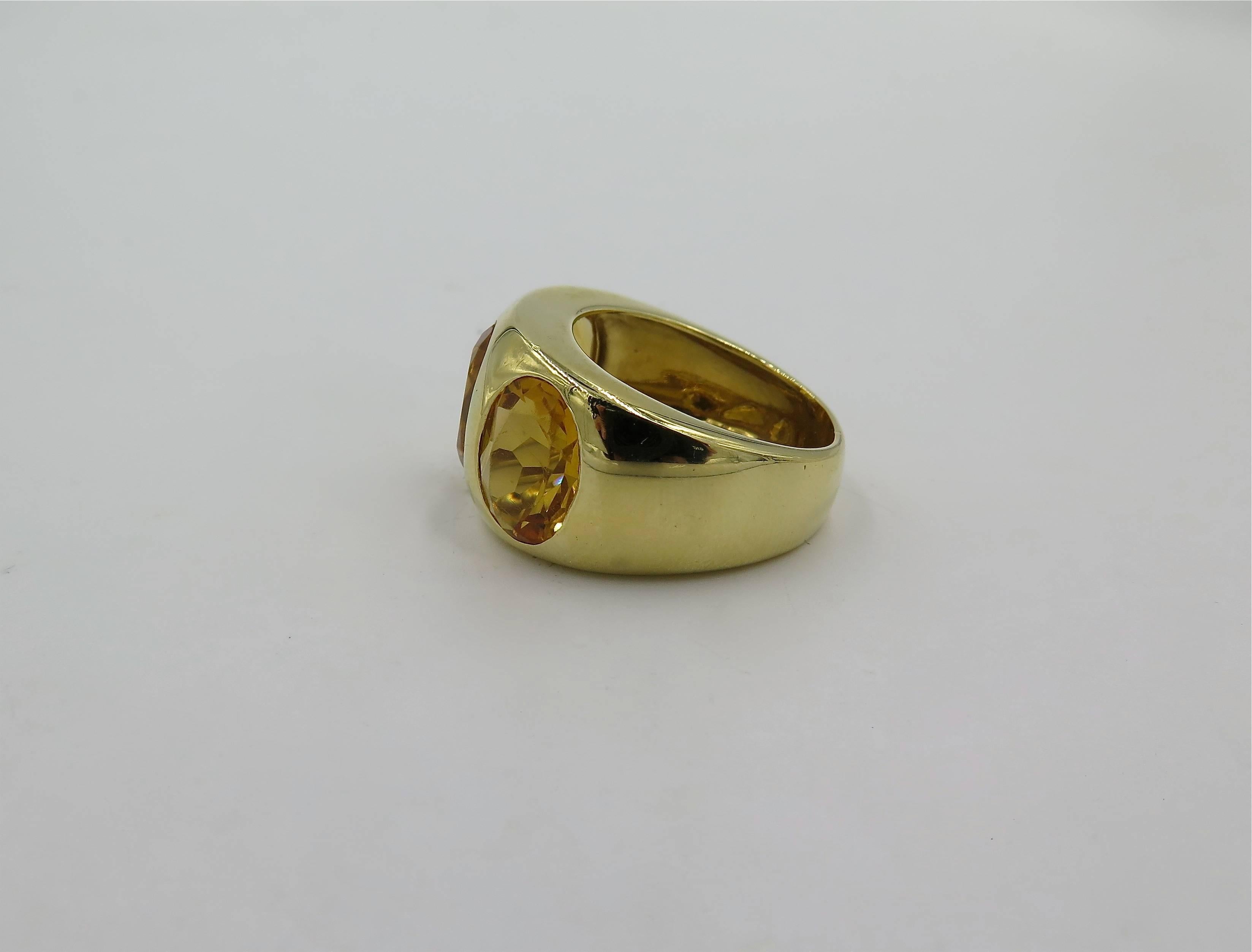 An 18 karat yellow gold three stone citrine ring. Criso. Italian. Designed as a wide polished gold band, centering three (3) gypsy set oval cut citrine, each measuring approximately 10.00 x 7.50 x 5.00mm, and each weighing approximately 2.00 carats.