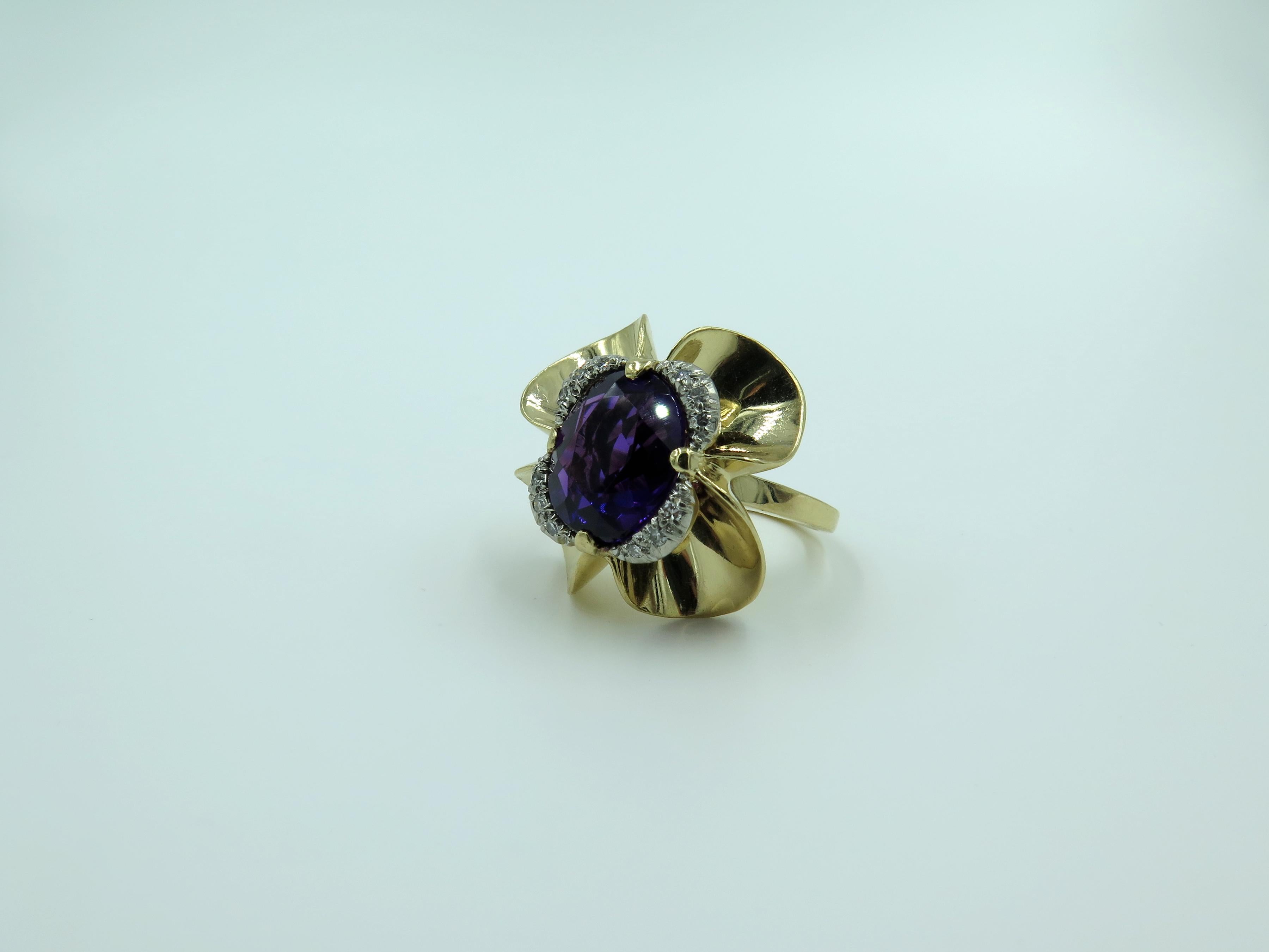 A 14 karat yellow gold, amethyst and diamond ring. Tiffany & Co. Circa 1940. Designed as a polished gold flower head, centering an oval cut amethyst, measuring approximately 11.50 x 10.00 x 5.70mm and weighing approximately 3.50 carats, within an