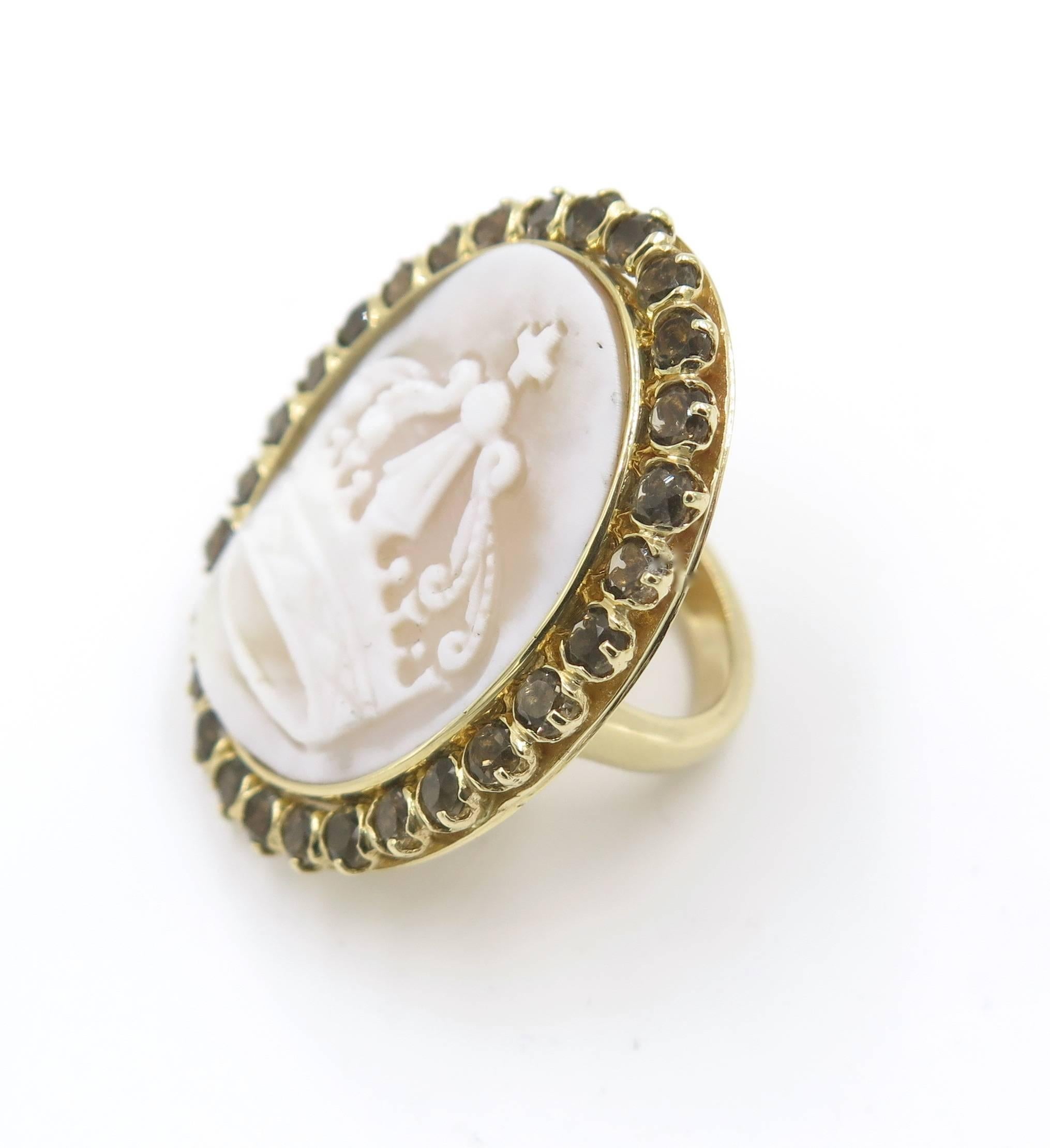 A 14 karat rose gold, shell cameo and smoky quartz ring. Set with a carved shell cameo of a crown, within a circular-cut smoky quartz surround. The ring has a gross weight of approximately 16.5 grams and is a size 6.